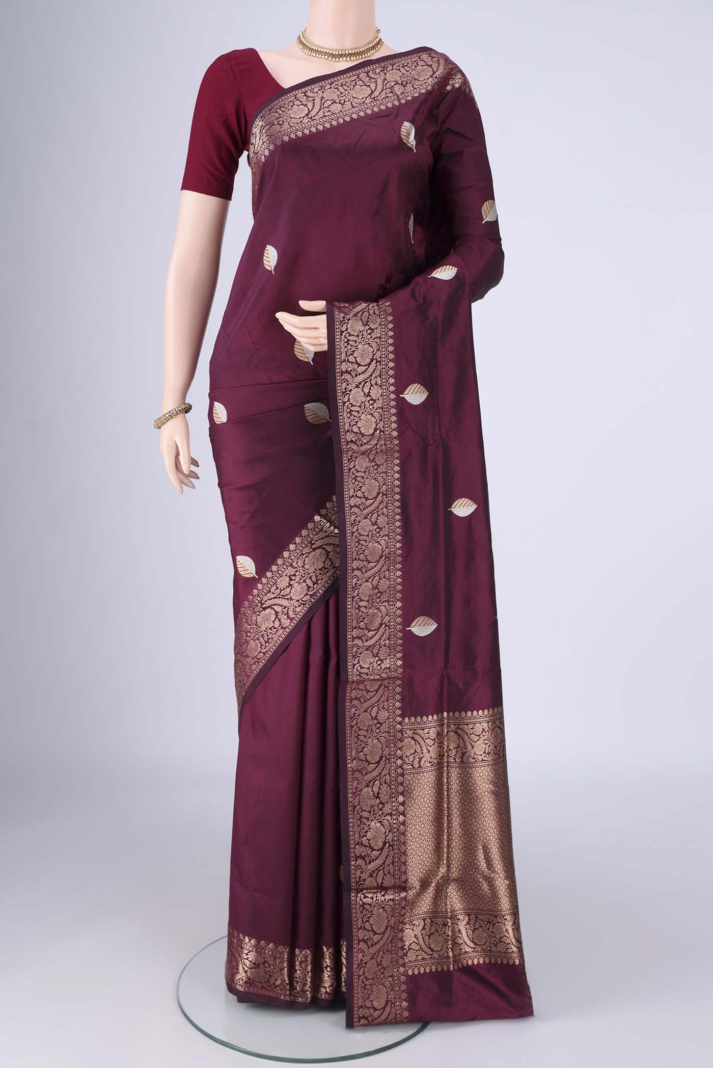 Burgundy Banarasi Katan Silk Saree with Zari Butta on the body and Zari Border.  displayed on a mannequin