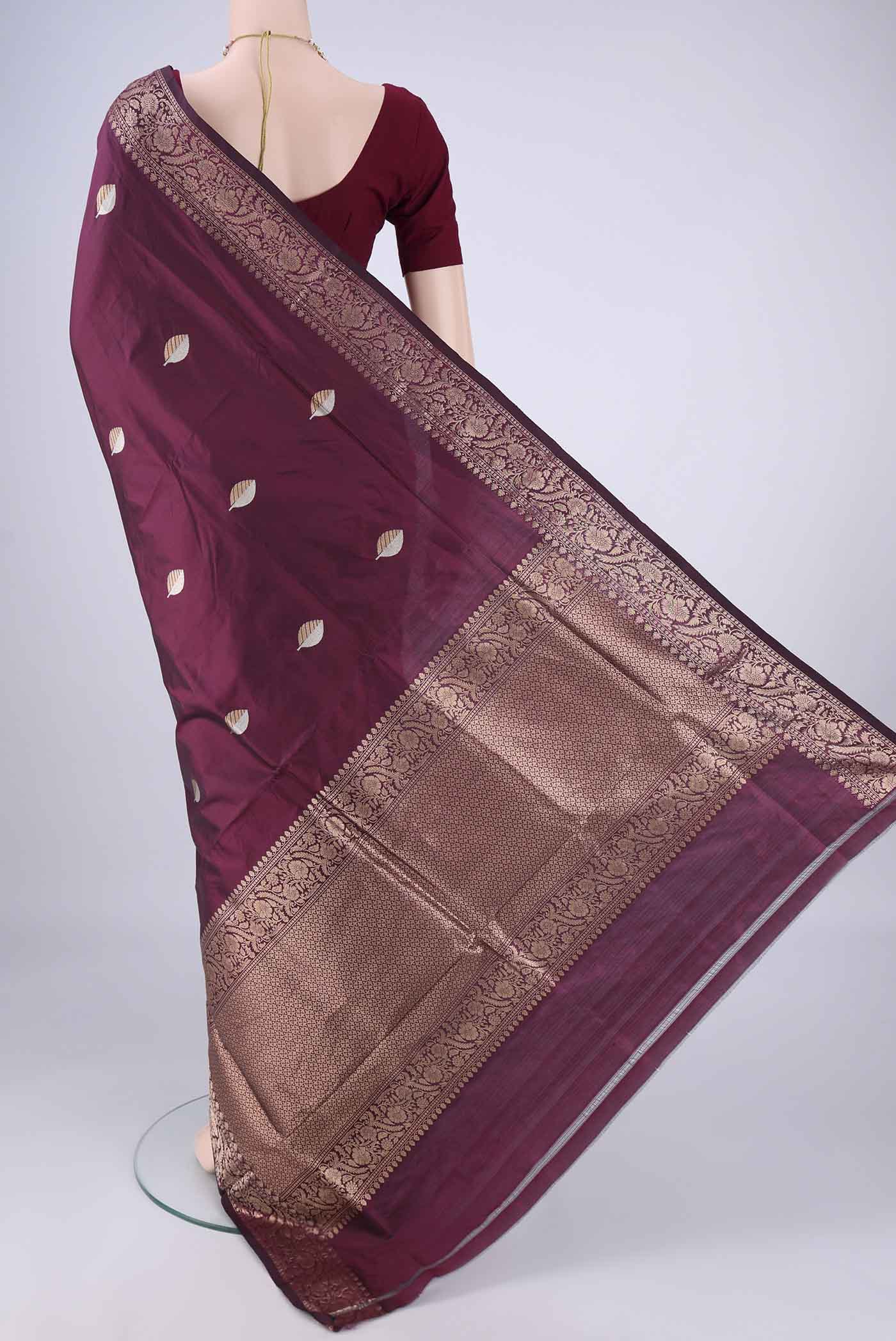 Flat view of Burgundy Banarasi Katan Silk Saree with Zari Butta on the body and Zari Border. 