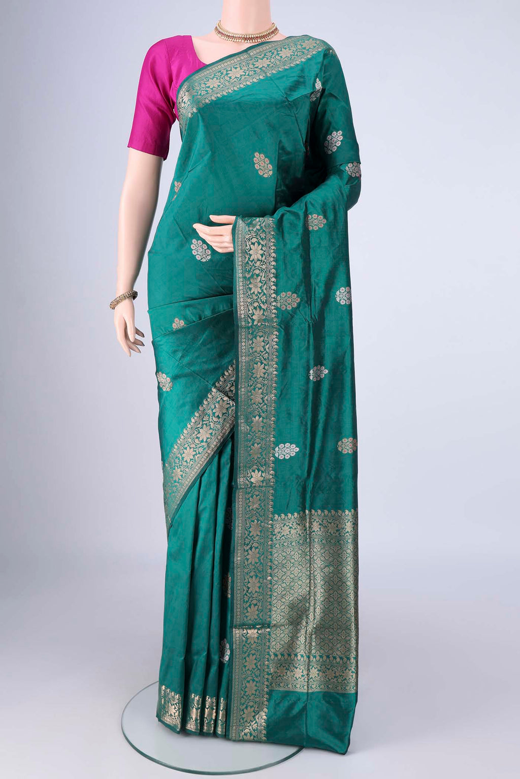 Teal Banarasi Katan Silk Saree with Zari And Thread Butta on the body and Zari Border.  displayed on a mannequin