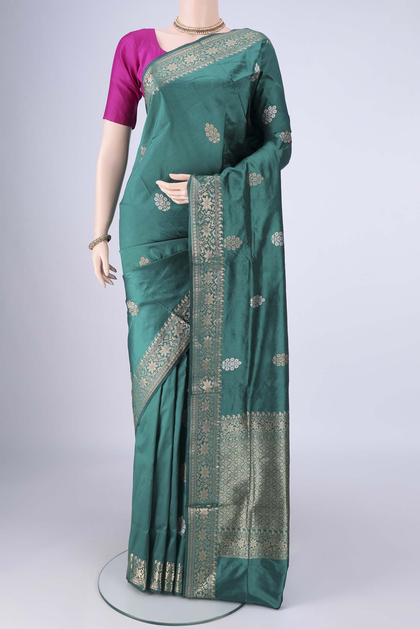 Teal Banarasi Katan Silk Saree with Zari And Thread Butta on the body and Zari Border.  displayed on a mannequin