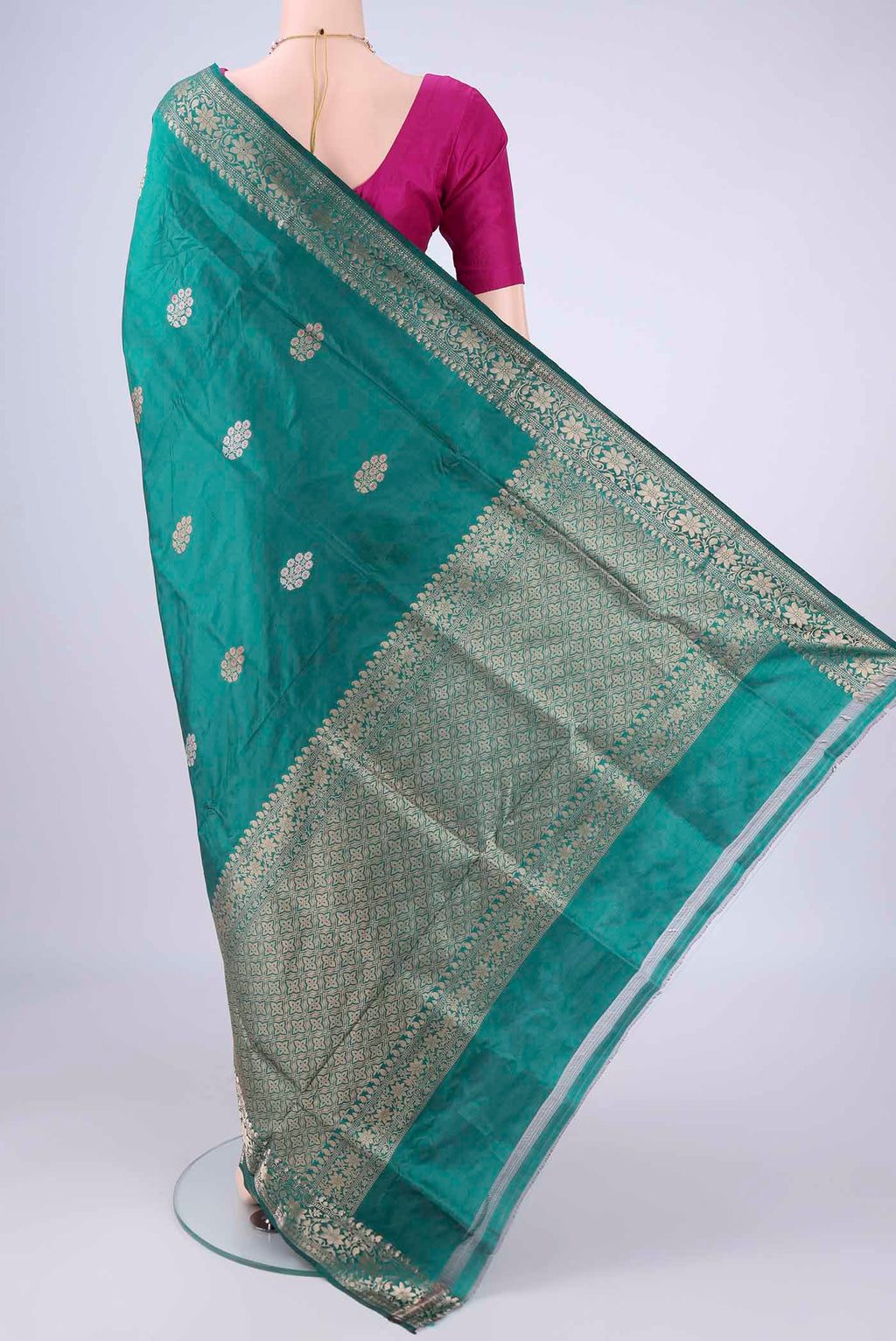 Flat view of Teal Banarasi Katan Silk Saree with Zari And Thread Butta on the body and Zari Border. 