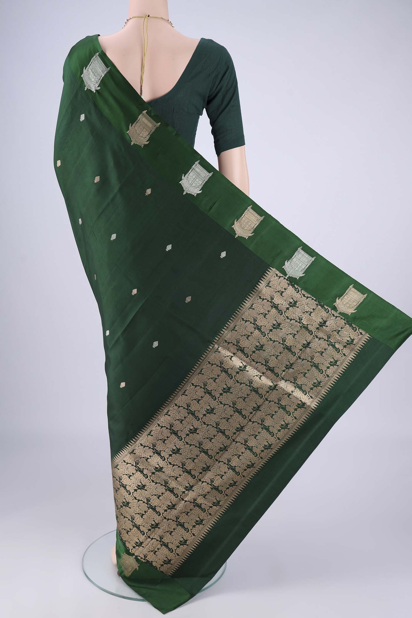Flat view of Bottle Green Banarasi Katan Silk Saree with Zari Butta on the body and Satin Border. 