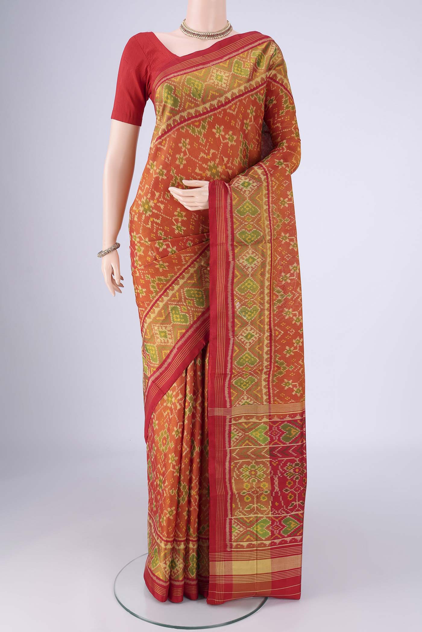 Brick Orange Rajkot Patola Silk Saree with Pure Ikat on the body and Ikat Border.  displayed on a mannequin