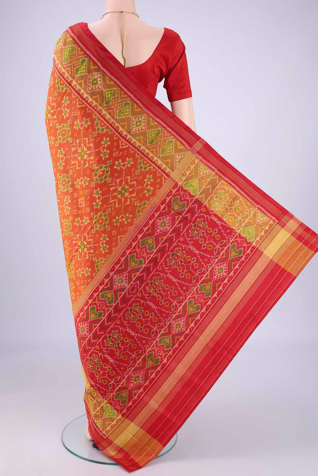 Flat view of Brick Orange Rajkot Patola Silk Saree with Pure Ikat on the body and Ikat Border. 