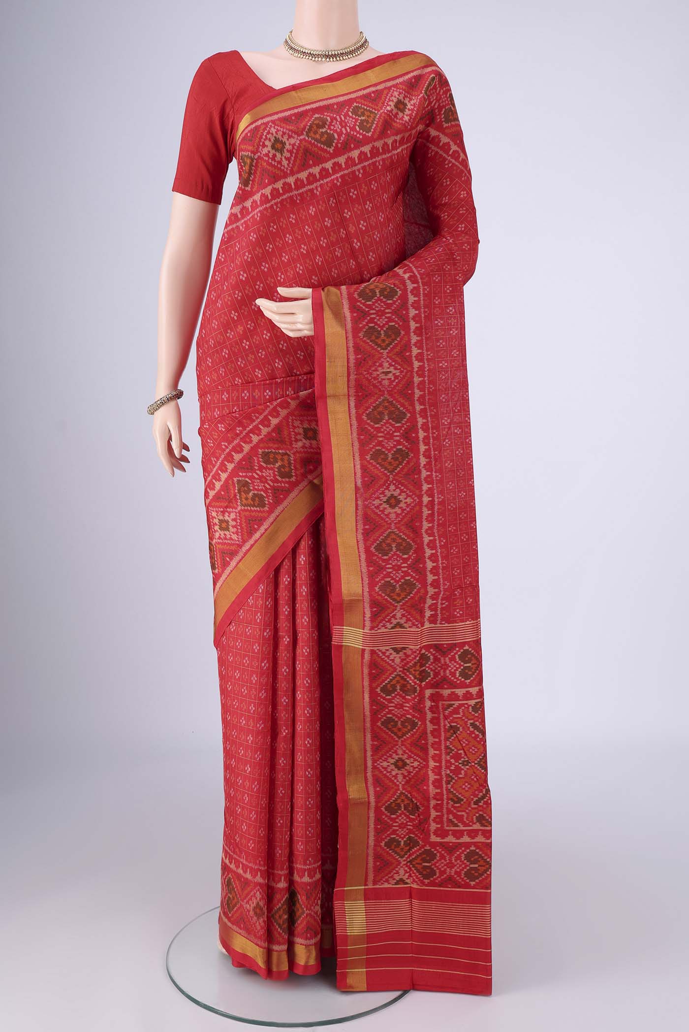 Red Rajkot Patola Silk Saree with Ikat design on the body and Ikat Border.  displayed on a mannequin