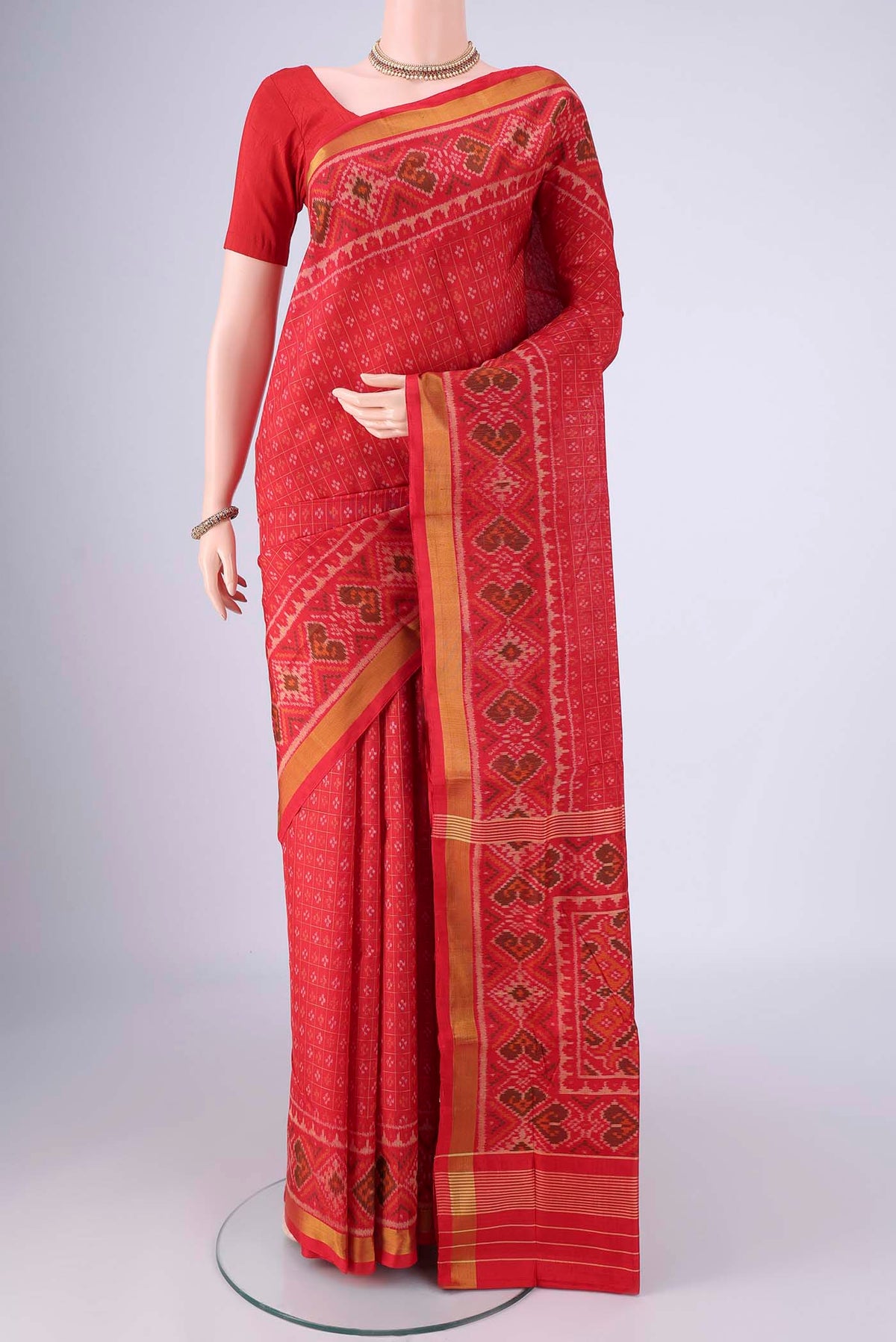 Red Rajkot Patola Silk Saree with Ikat design on the body and Ikat Border.  displayed on a mannequin
