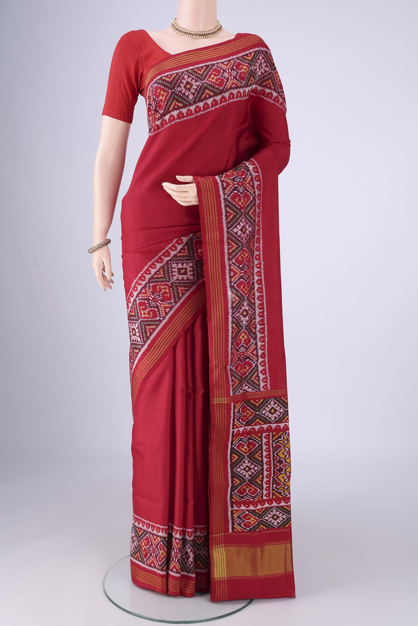 Red Rajkot Patola Silk Saree with Plain Body and Ikat Border.  displayed on a mannequin