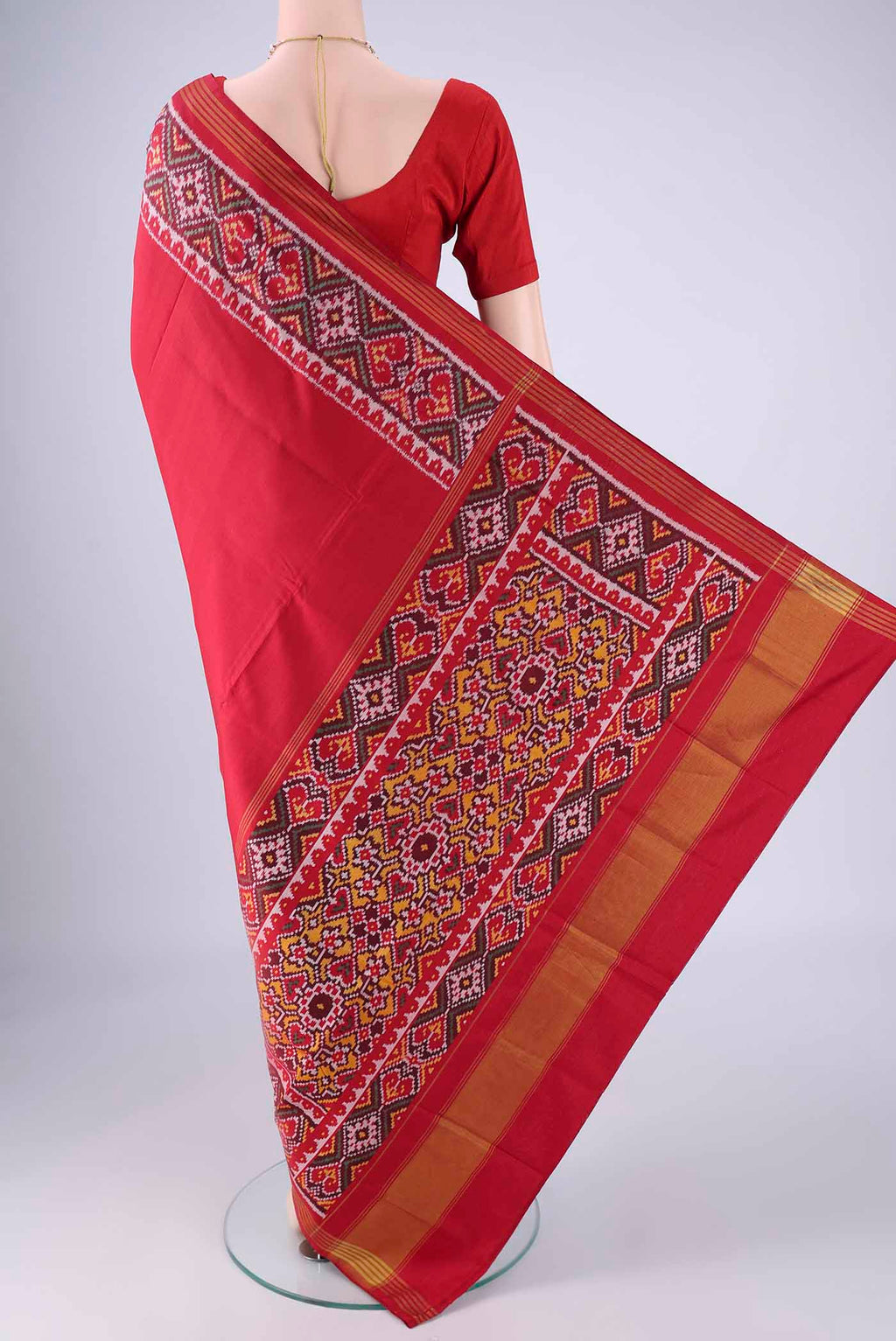 Flat view of Red Rajkot Patola Silk Saree with Plain Body and Ikat Border. 