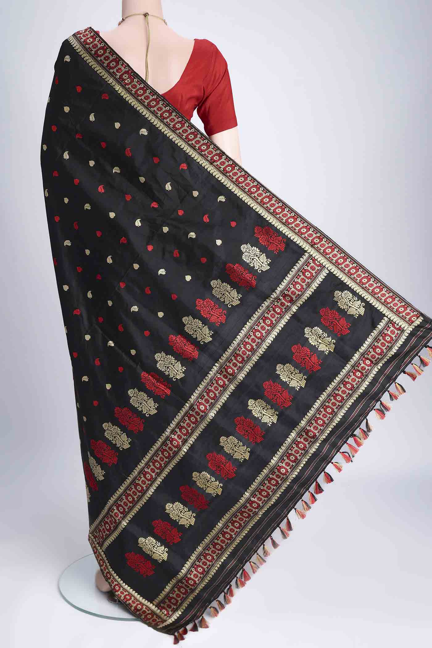 Flat view of Black Assam Silk Saree with Thread Butta on the body and Thread Border. 