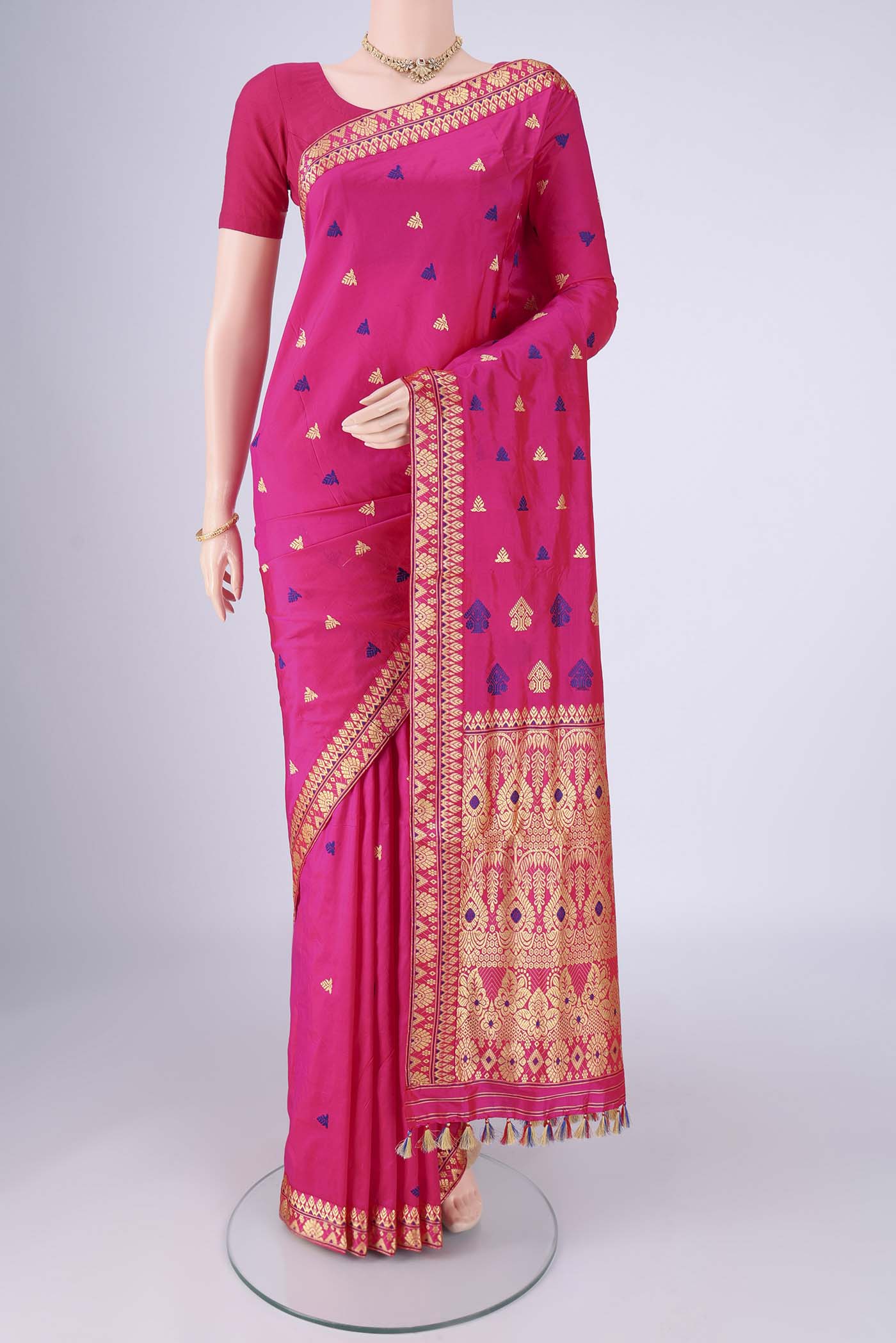 Rani Pink Assam Silk Saree with Thread Butta on the body and Thread Border.  displayed on a mannequin