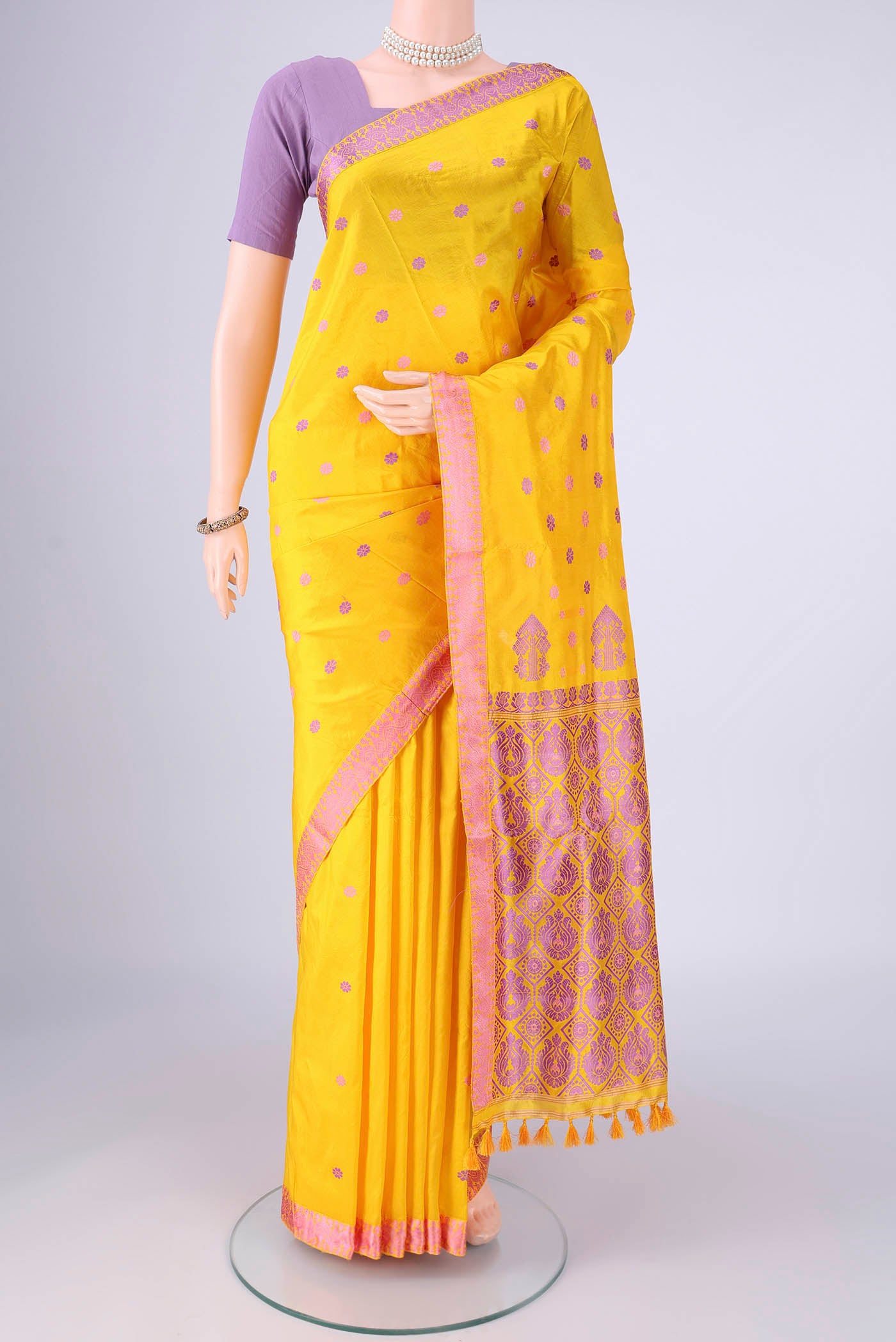 Yellow Assam Silk Saree with Thread Butta on the body and Thread Border.  displayed on a mannequin