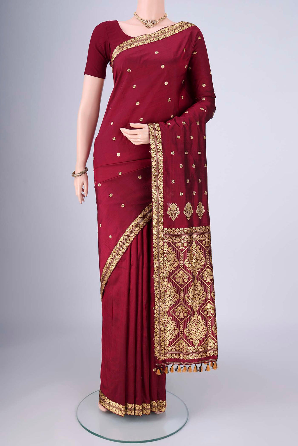 Maroon Assam Silk Saree with Thread Butta on the body and Thread Border.  displayed on a mannequin