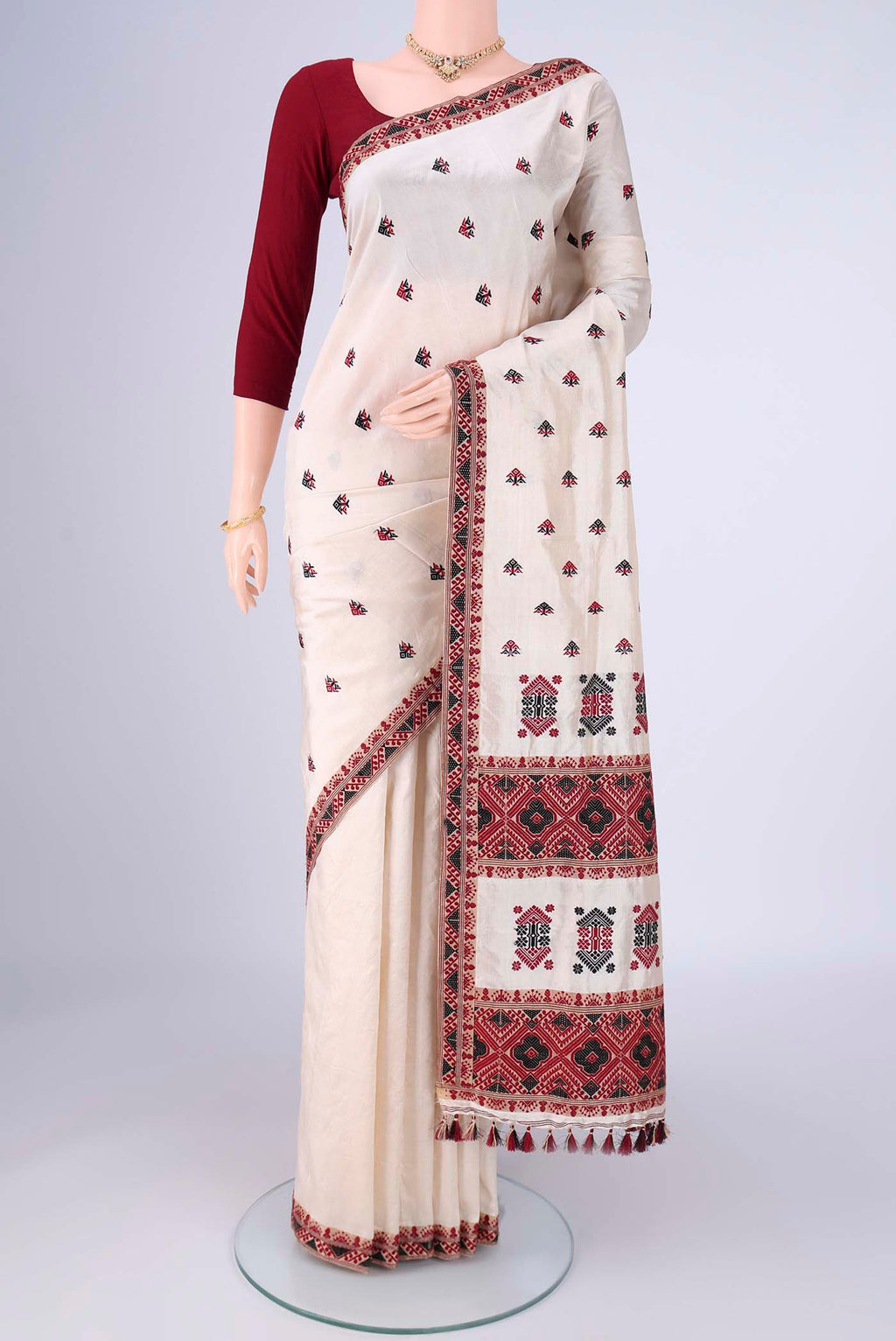 Cream Assam Silk Saree with Thread Butta on the body and Thread Border.  displayed on a mannequin