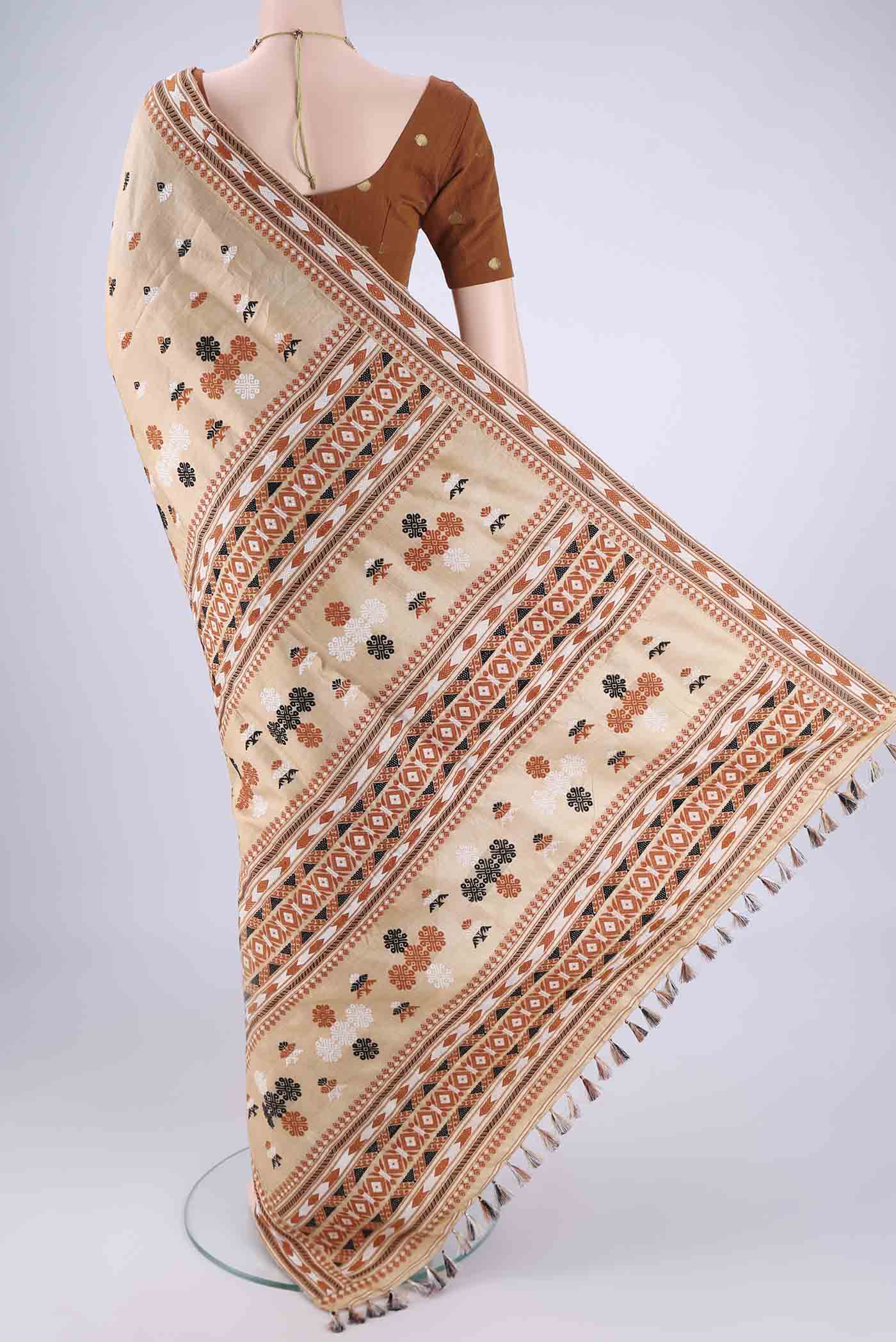 Flat view of Beige Assam Silk Saree with Thread Butta on the body and Thread Border. 