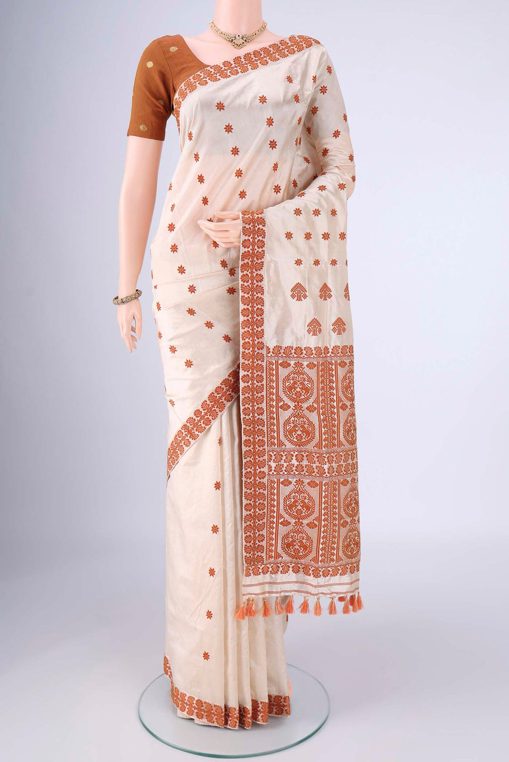 Cream Assam Silk Saree with Thread Butta on the body and Thread Border.  displayed on a mannequin