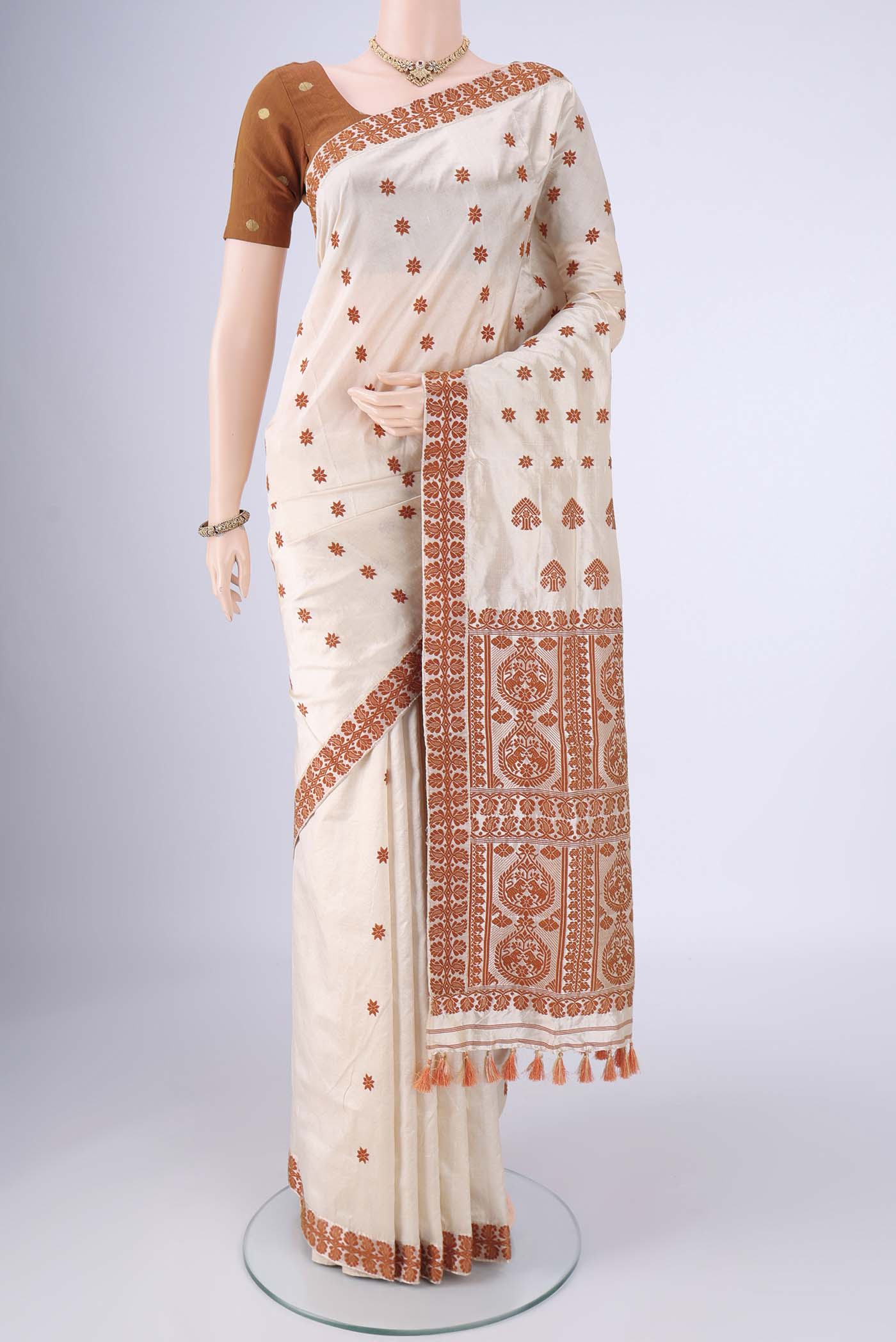 Cream Assam Silk Saree with Thread Butta on the body and Thread Border.  displayed on a mannequin