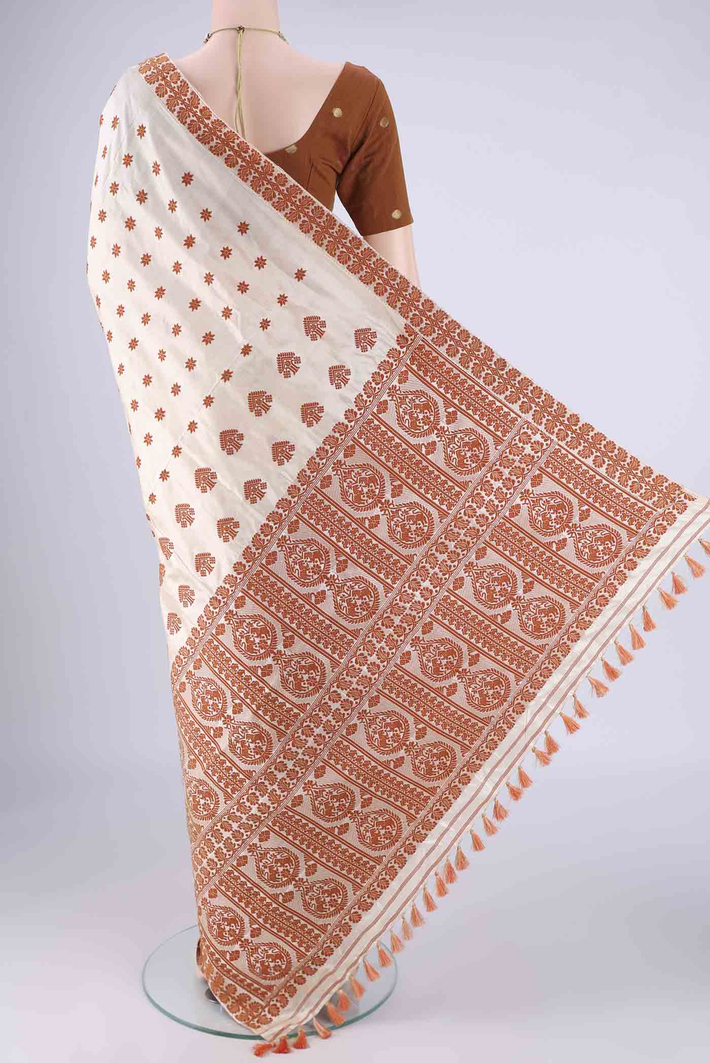 Flat view of Cream Assam Silk Saree with Thread Butta on the body and Thread Border. 