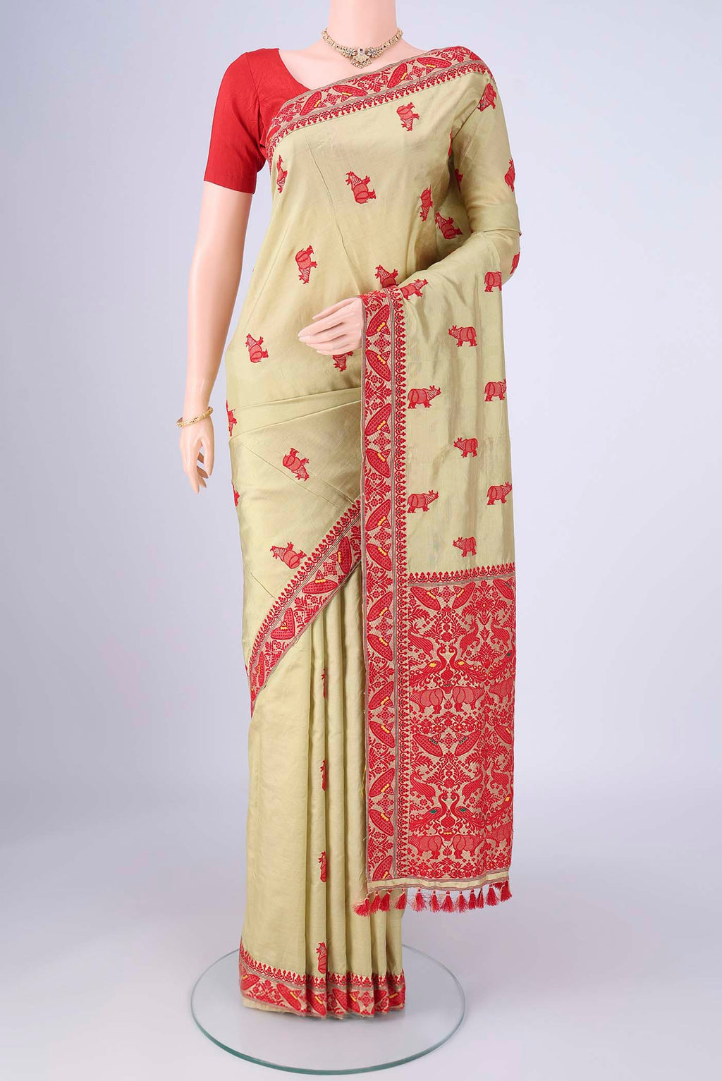 Sage Green Assam Silk Saree with Thread Butta on the body and Thread Border.  displayed on a mannequin