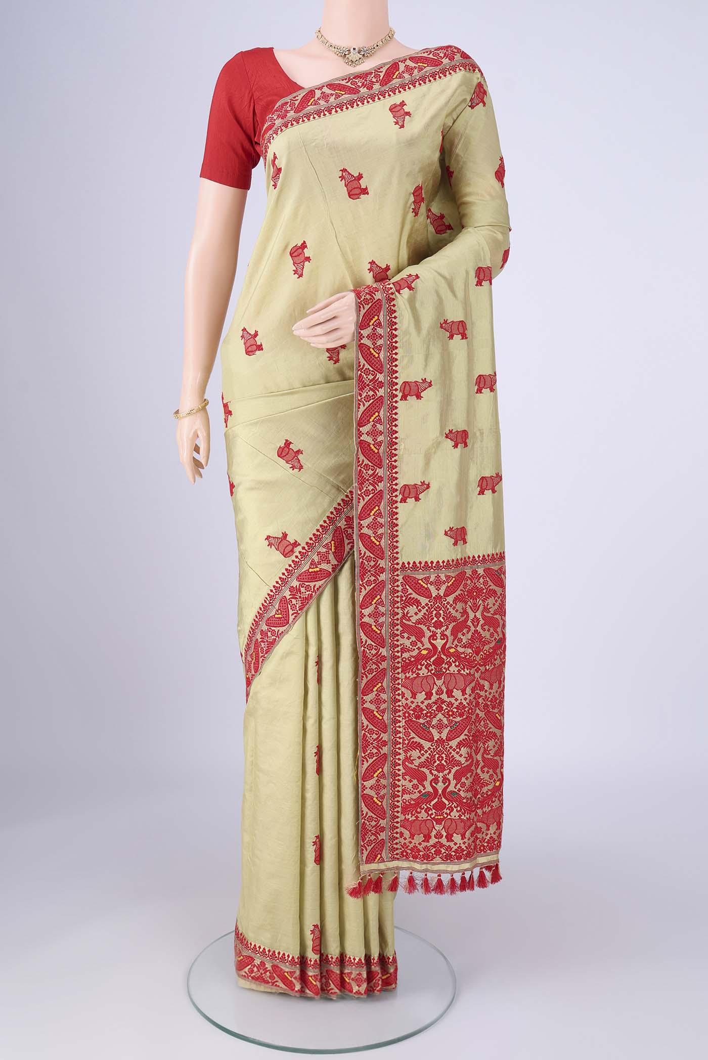 Sage Green Assam Silk Saree with Thread Butta on the body and Thread Border.  displayed on a mannequin