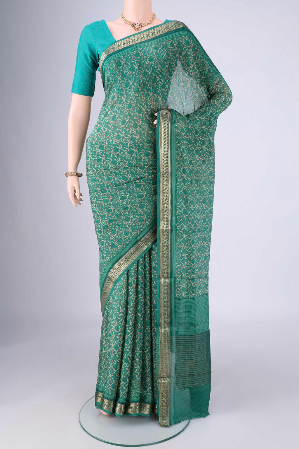 Sea Green Mysore Crepe Saree with Printed design on the body and Zari Border.  displayed on a mannequin