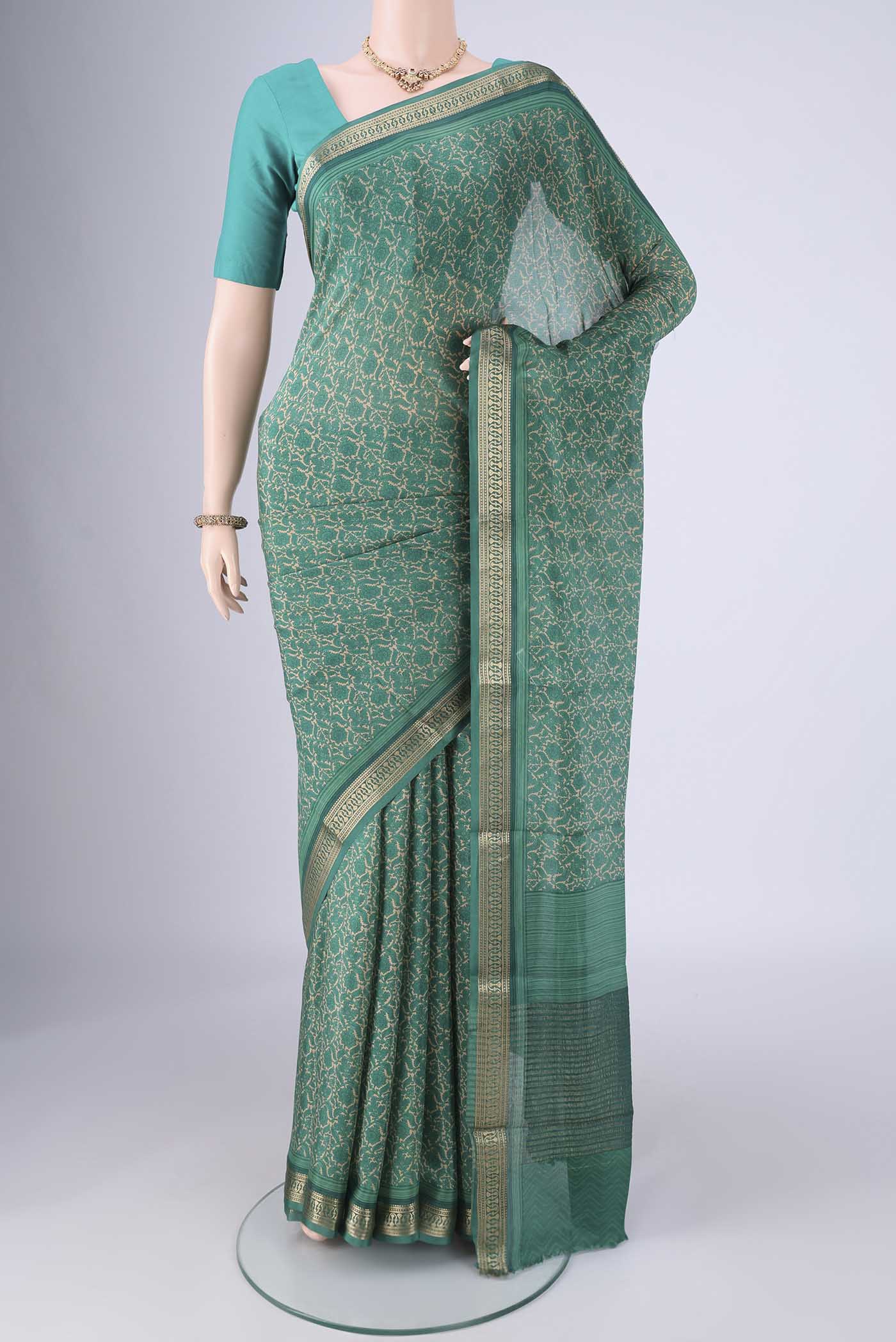 Sea Green Mysore Crepe Saree with Printed design on the body and Zari Border.  displayed on a mannequin
