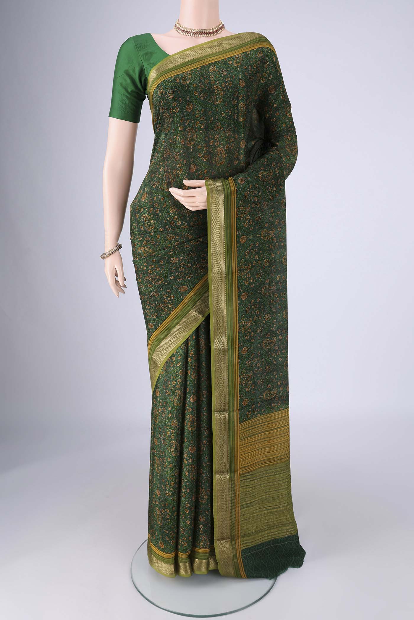 Bottle Green Mysore Crepe Saree with Printed design on the body and Zari Border.  displayed on a mannequin