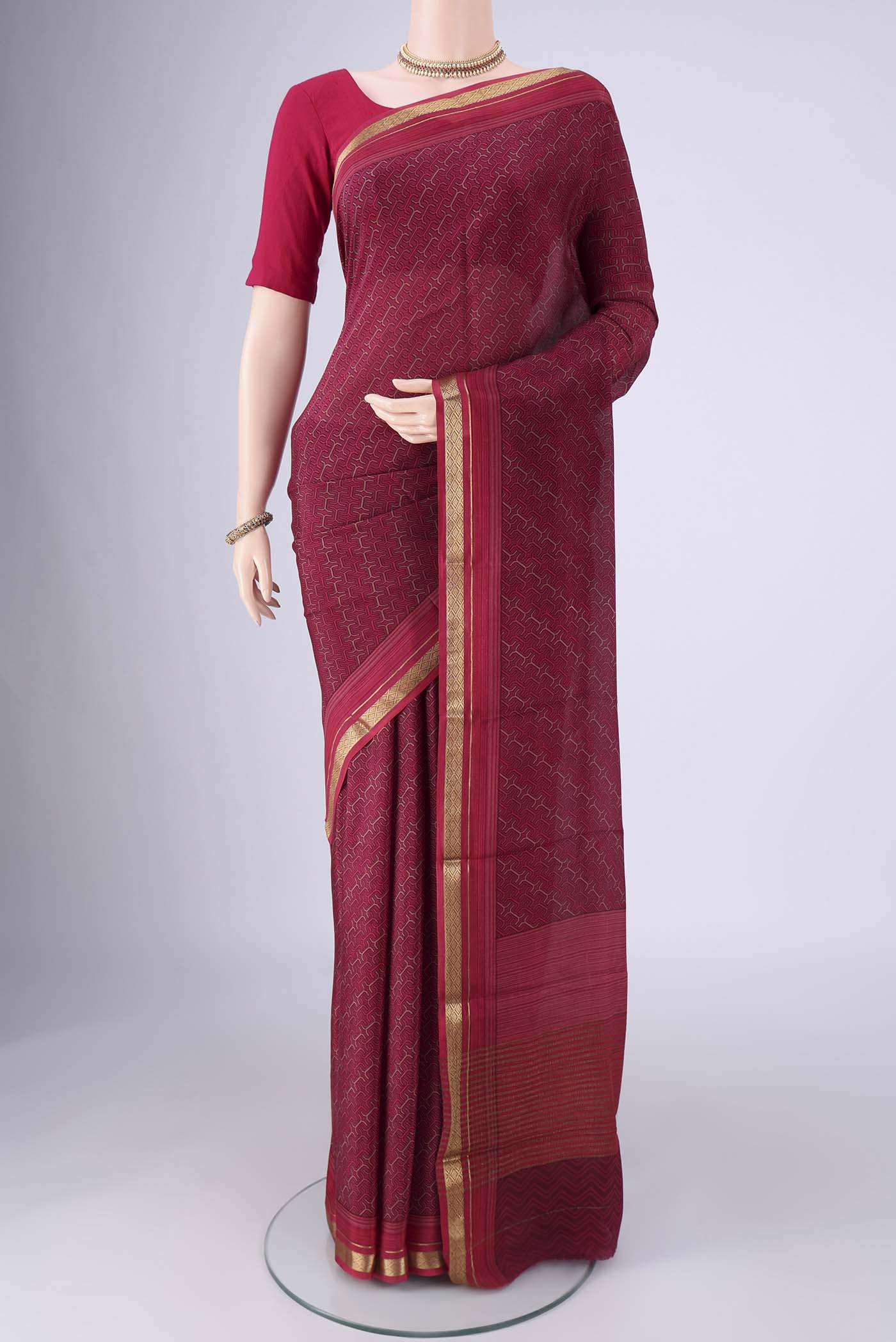 Magenta Mysore Crepe Saree with Printed design on the body and Zari Border.  displayed on a mannequin