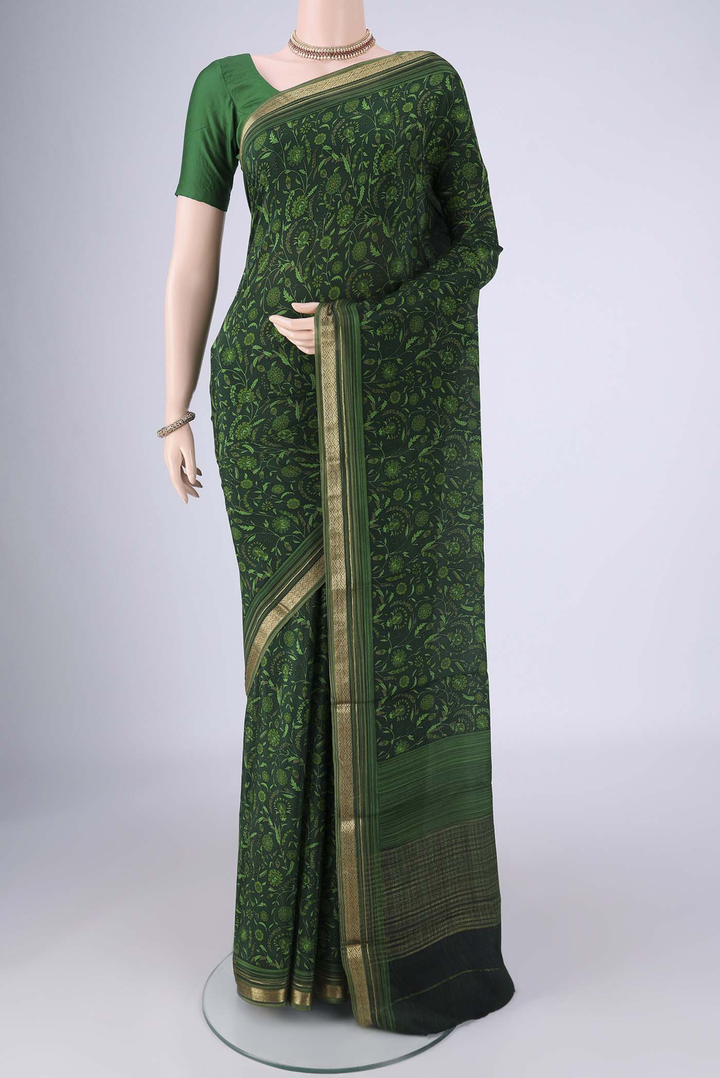 Bottle Green Mysore Crepe Saree with Printed design on the body and Zari Border.  displayed on a mannequin