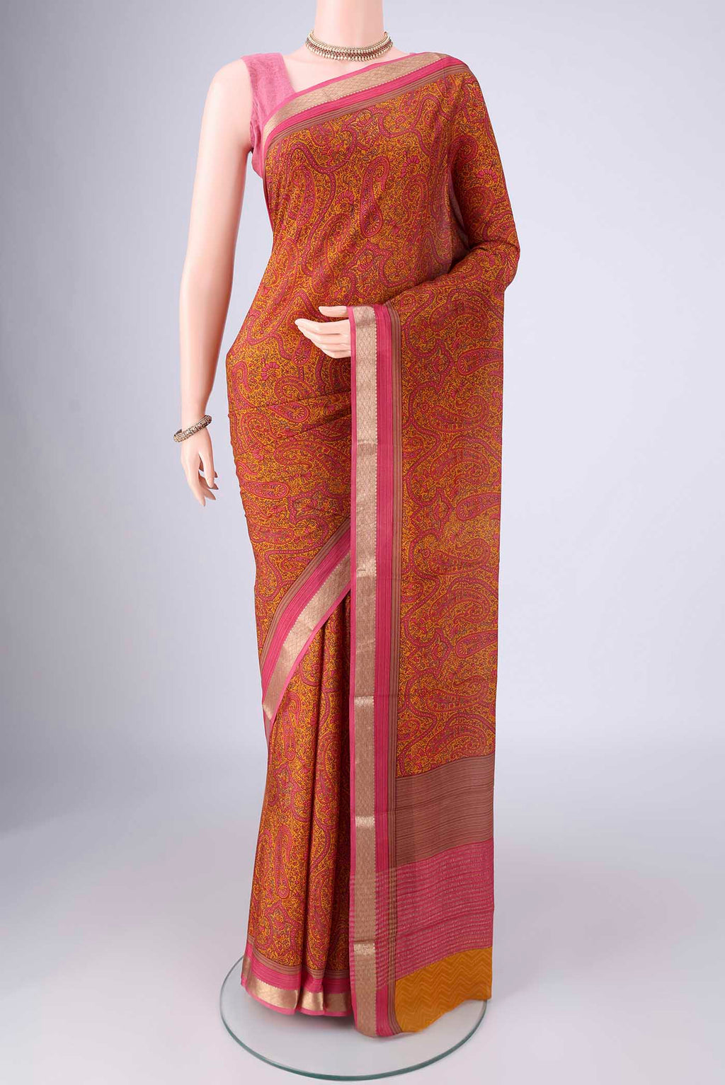 Mustard Mysore Crepe Saree with Printed design on the body and Zari Border.  displayed on a mannequin