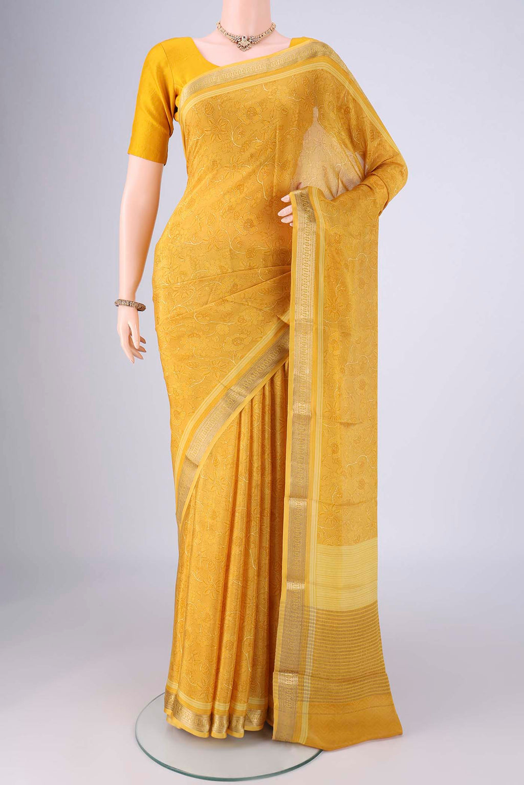 Yellow Mysore Crepe Saree with Printed design on the body and Zari Border.  displayed on a mannequin