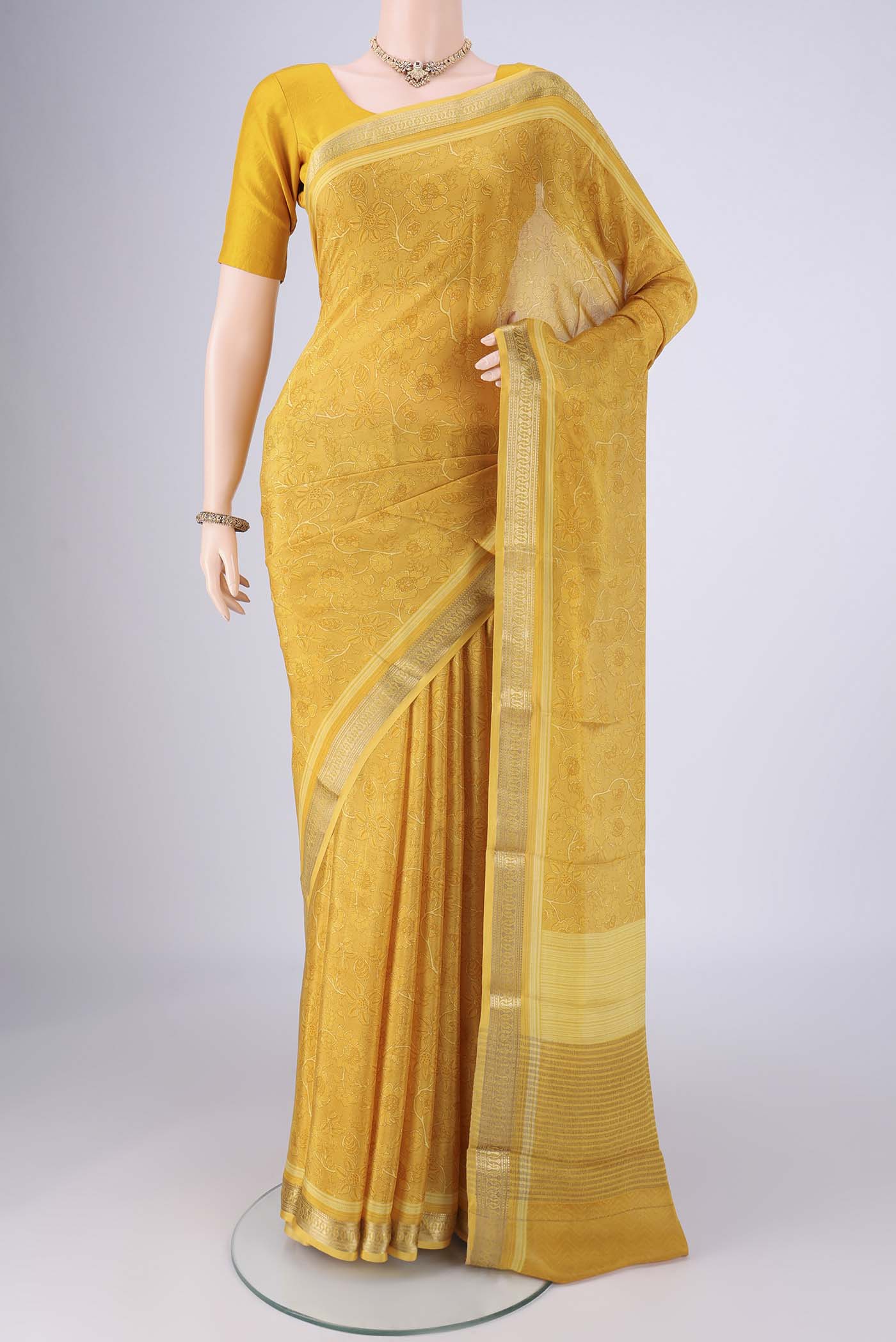 Yellow Mysore Crepe Saree with Printed design on the body and Zari Border.  displayed on a mannequin