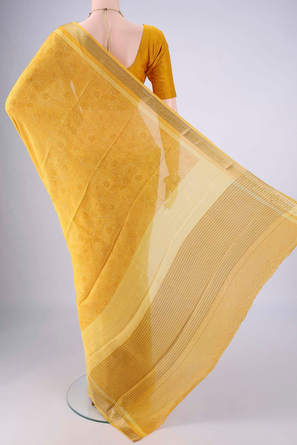 Flat view of Yellow Mysore Crepe Saree with Printed design on the body and Zari Border. 