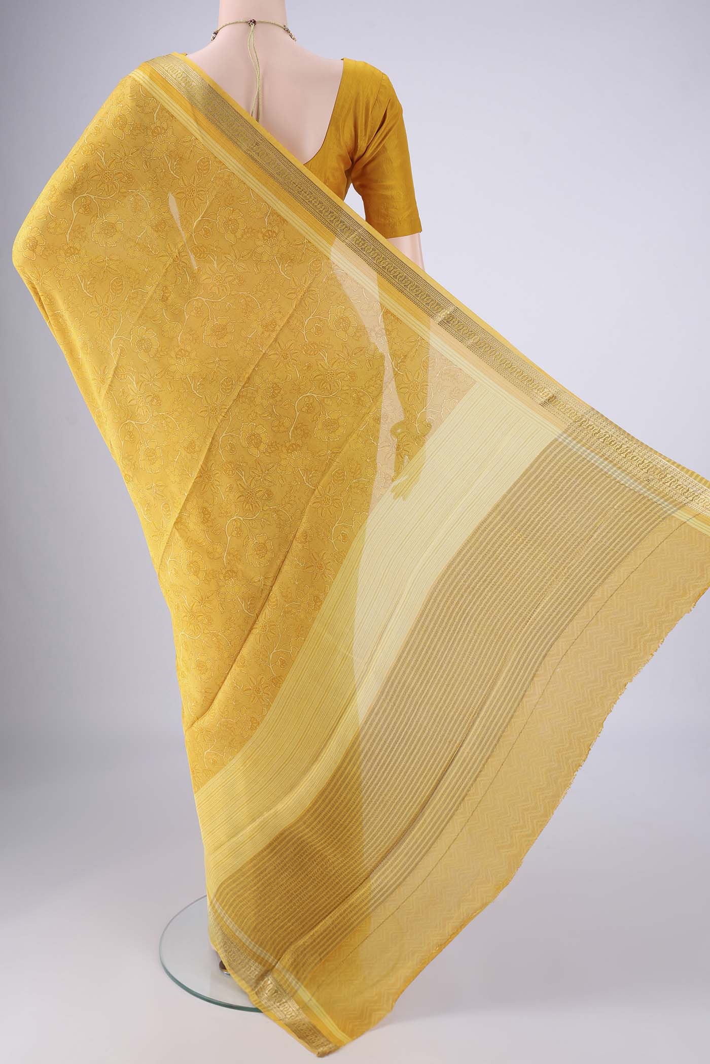 Flat view of Yellow Mysore Crepe Saree with Printed design on the body and Zari Border. 
