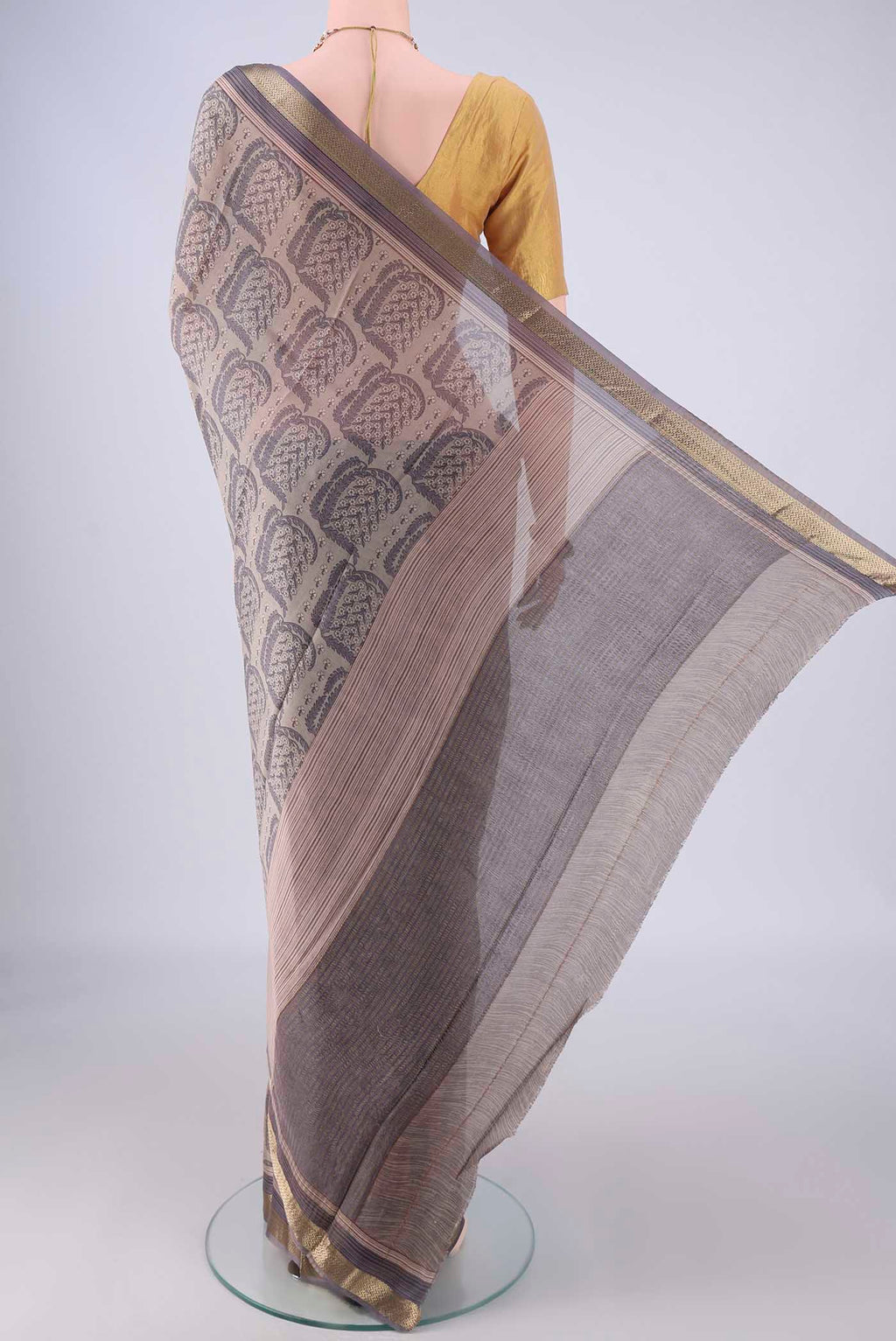Flat view of Grey Crepe Saree with Floral Print on the body and Zari Border. 