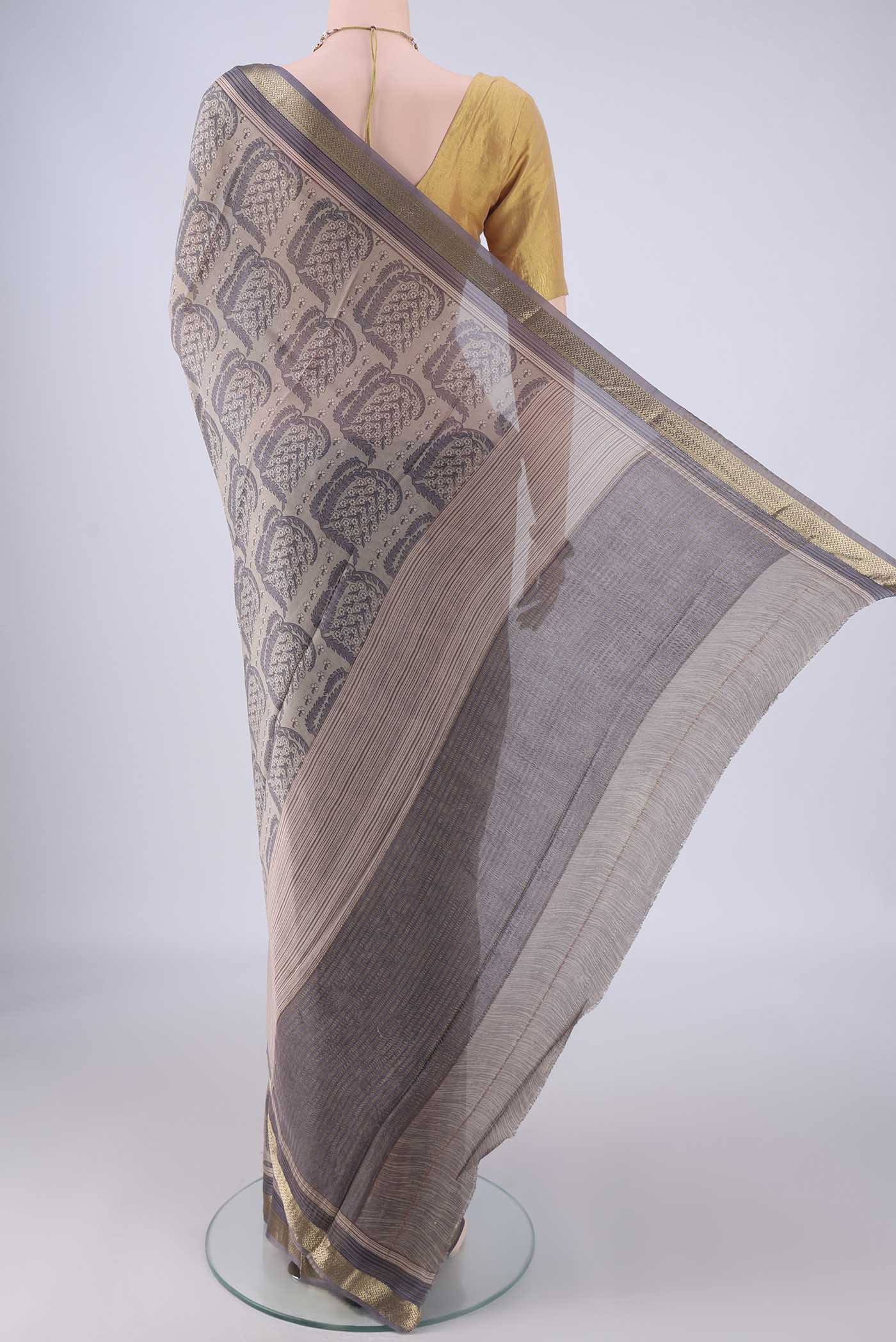 Flat view of Grey Crepe Saree with Floral Print on the body and Zari Border. 