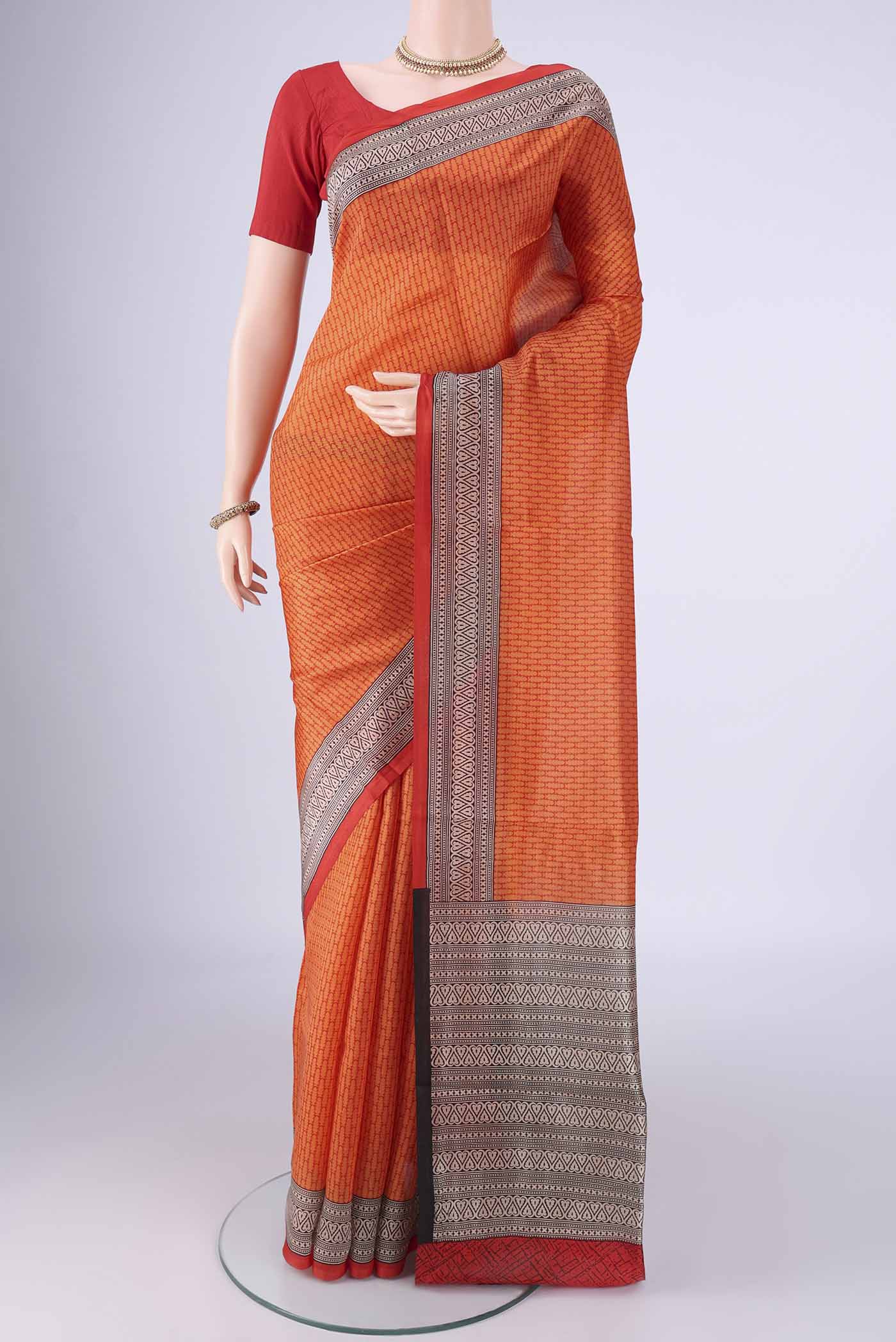 Orange Printed Silk Saree with Printed design on the body and Printed Border.  displayed on a mannequin