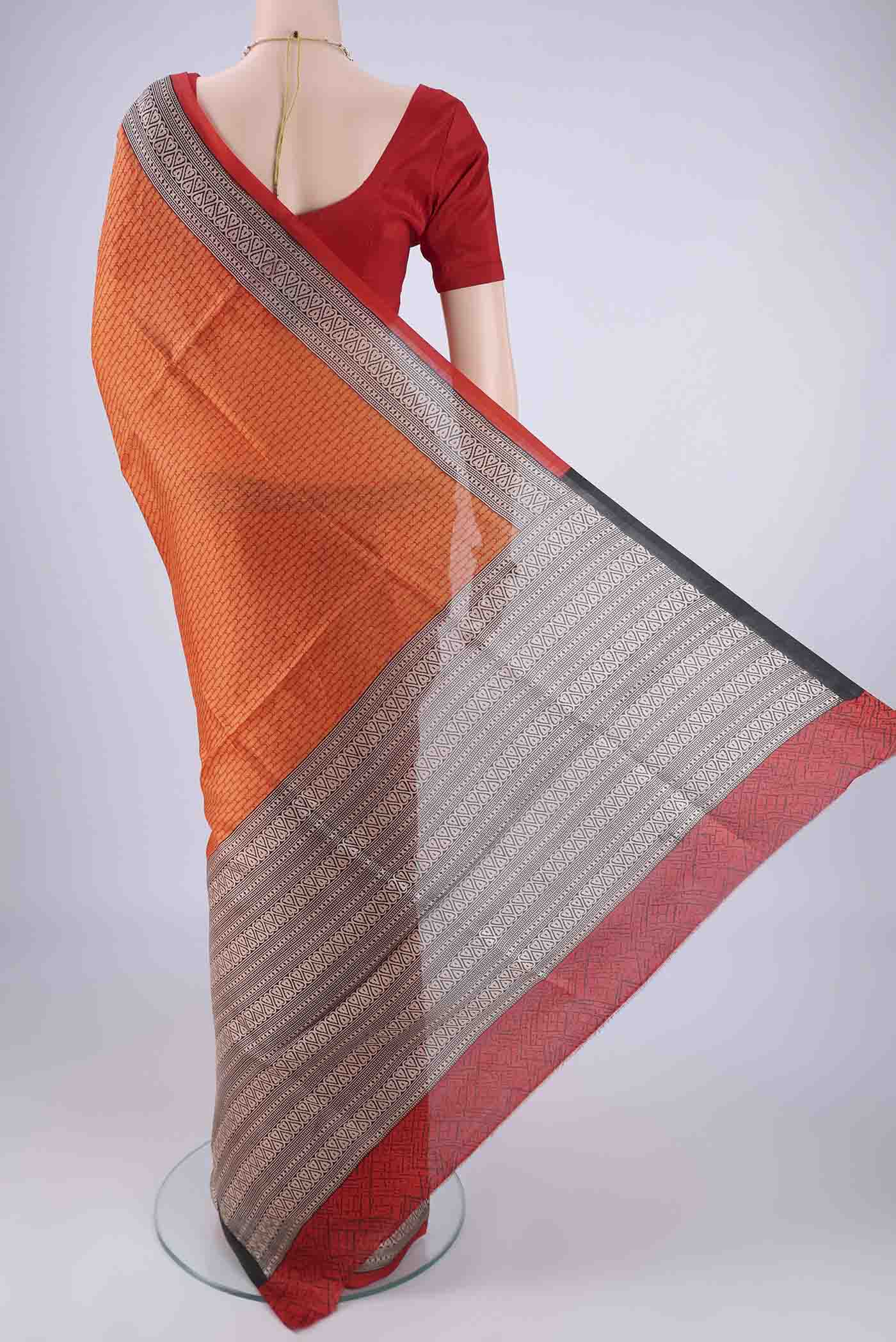 Flat view of Orange Printed Silk Saree with Printed design on the body and Printed Border. 