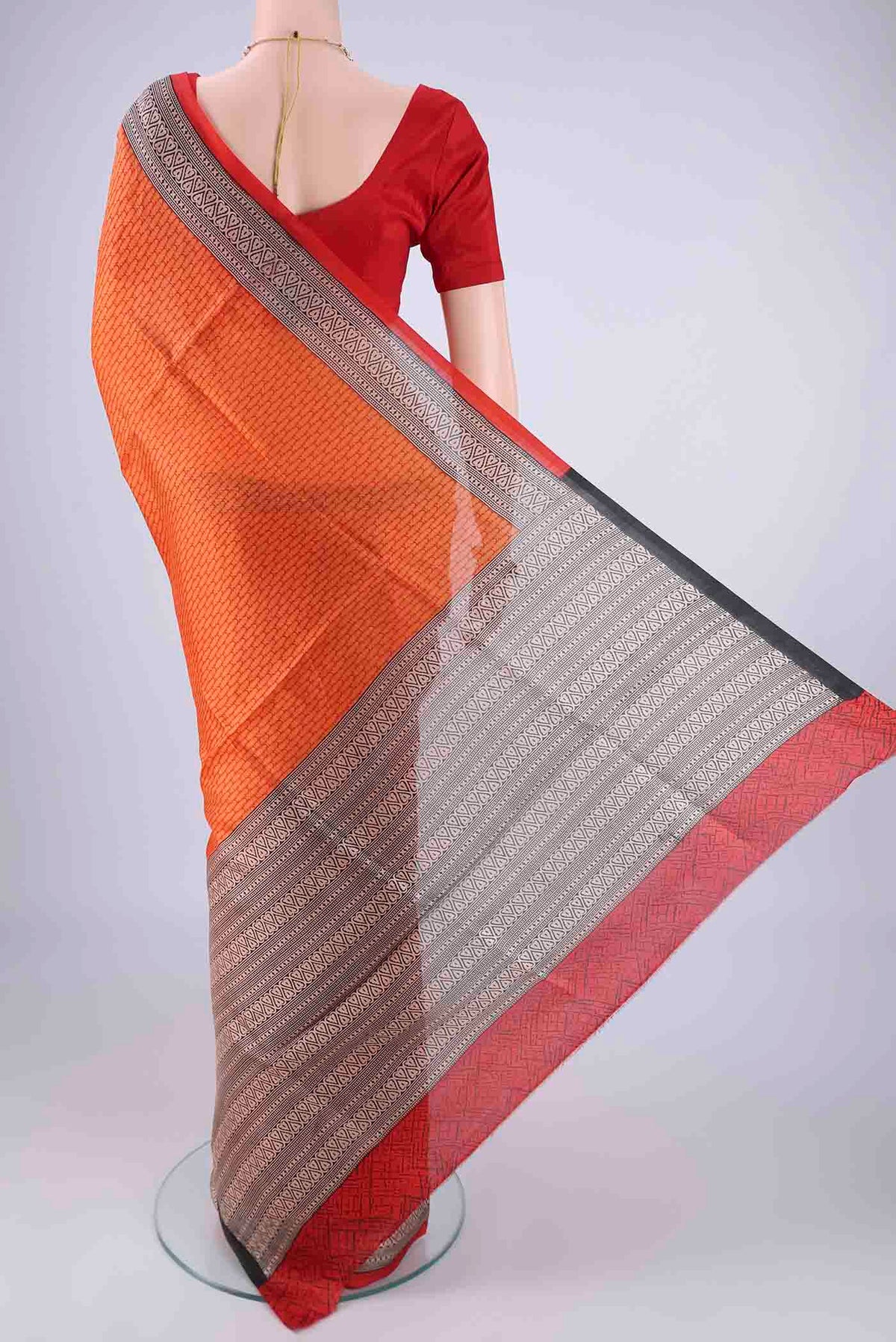 Flat view of Orange Printed Silk Saree with Printed design on the body and Printed Border. 