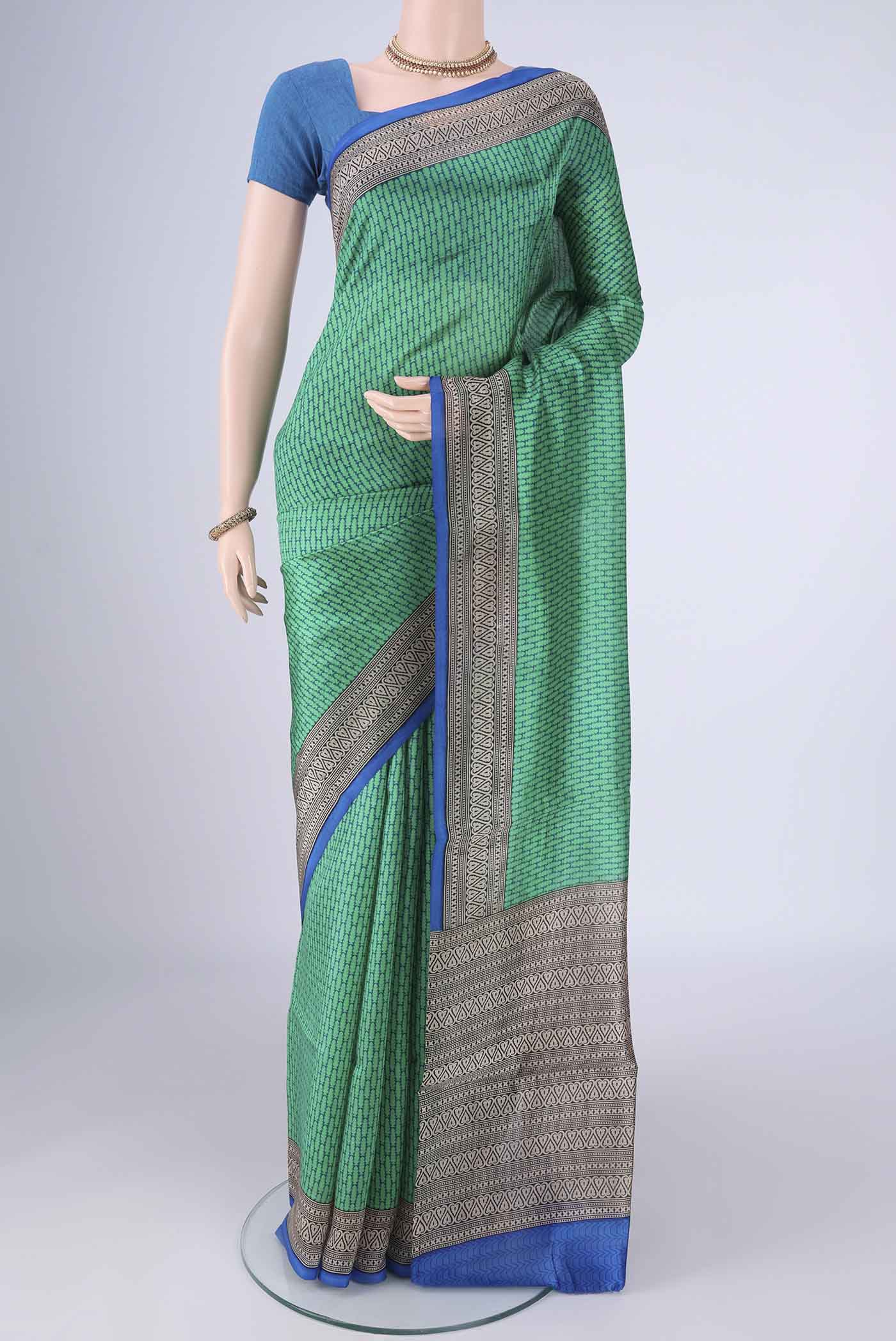 Green Printed Silk Saree with Printed design on the body and Printed Border.  displayed on a mannequin