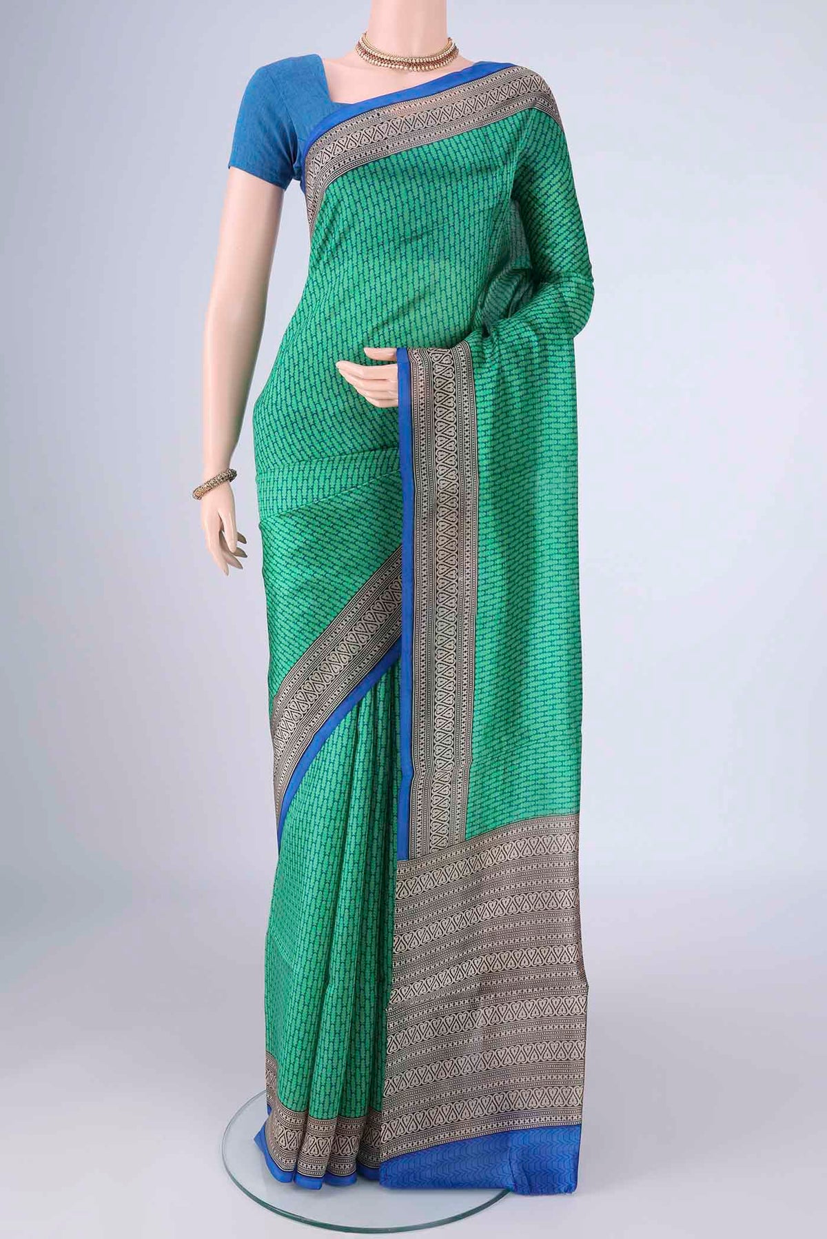 Green Printed Silk Saree with Printed design on the body and Printed Border.  displayed on a mannequin