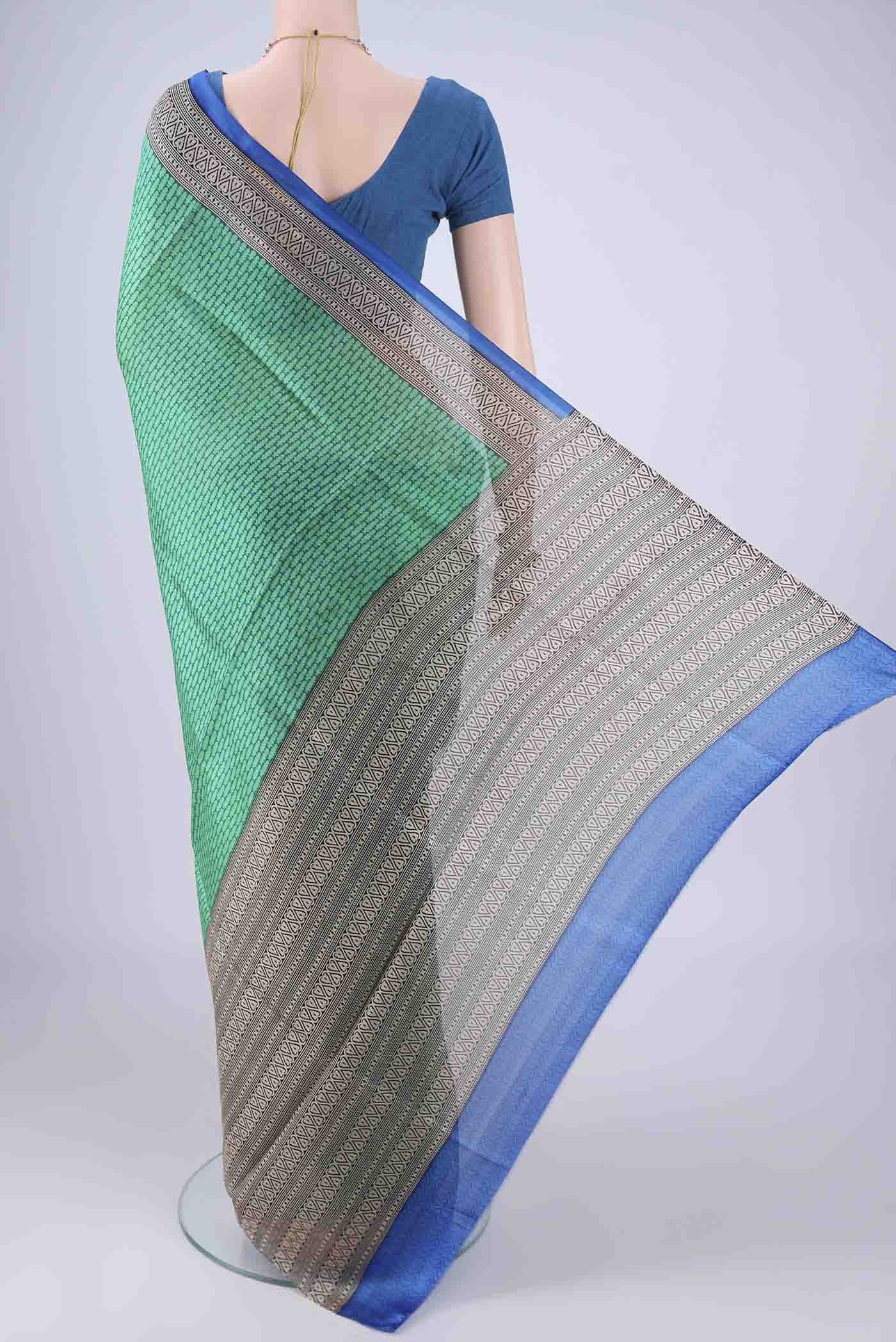 Flat view of Green Printed Silk Saree with Printed design on the body and Printed Border. 