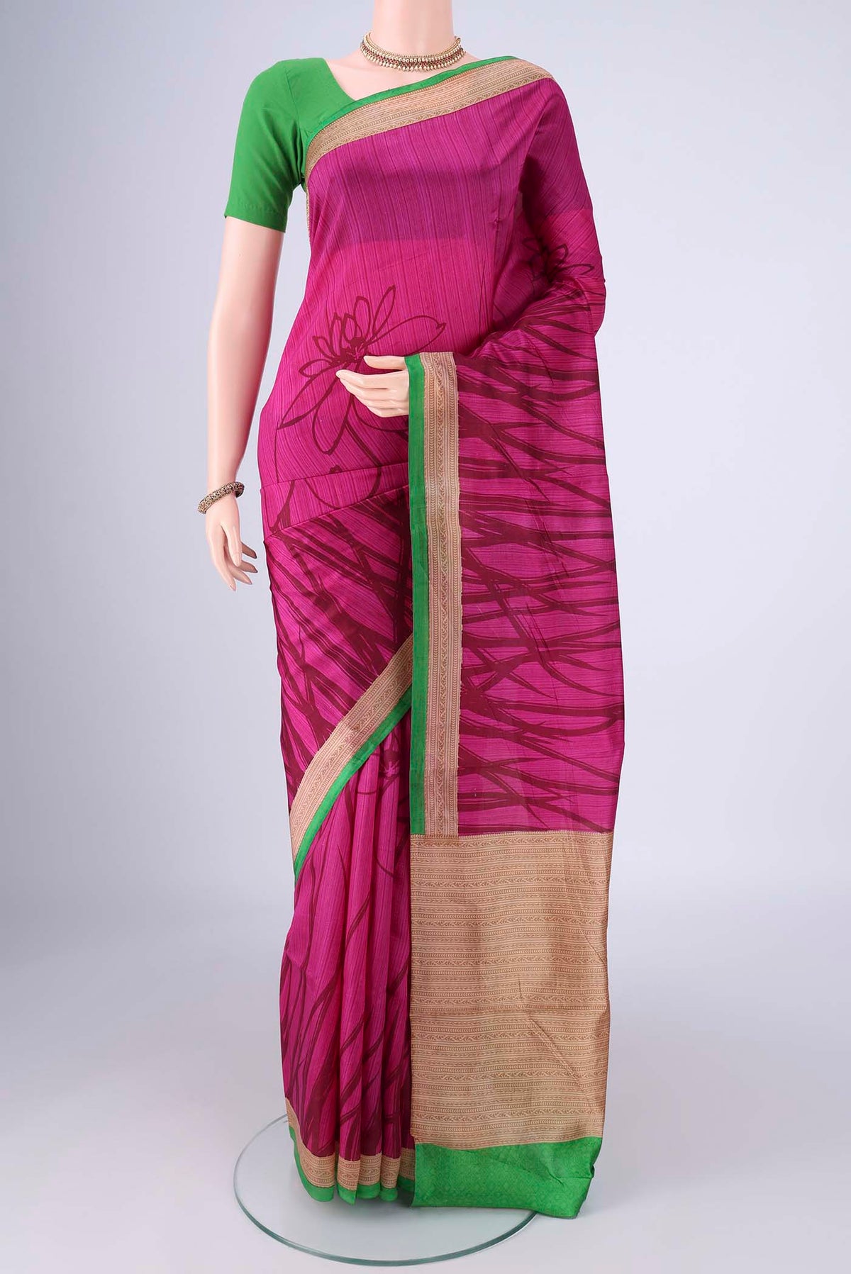 Rani Pink Printed Silk Saree with Printed design on the body and Printed Border.  displayed on a mannequin