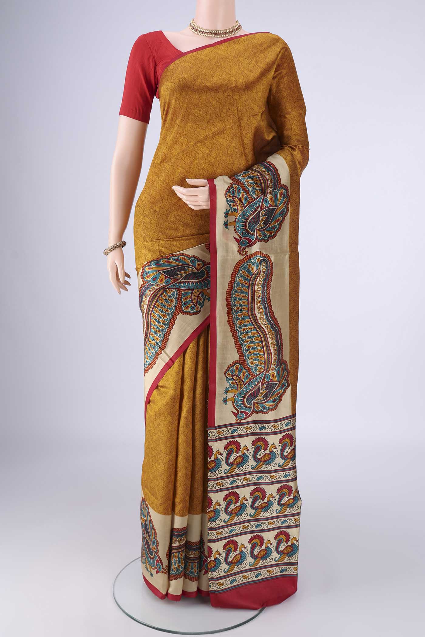 Mustard Printed Silk Saree with Printed design on the body and Plain Border.  displayed on a mannequin