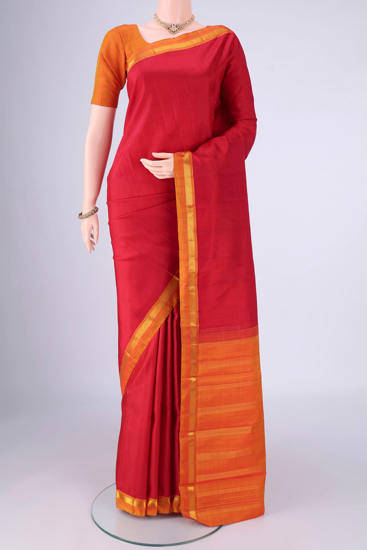 Red Kanjivaram Silk Saree with Plain Body and Zari Border.  displayed on a mannequin