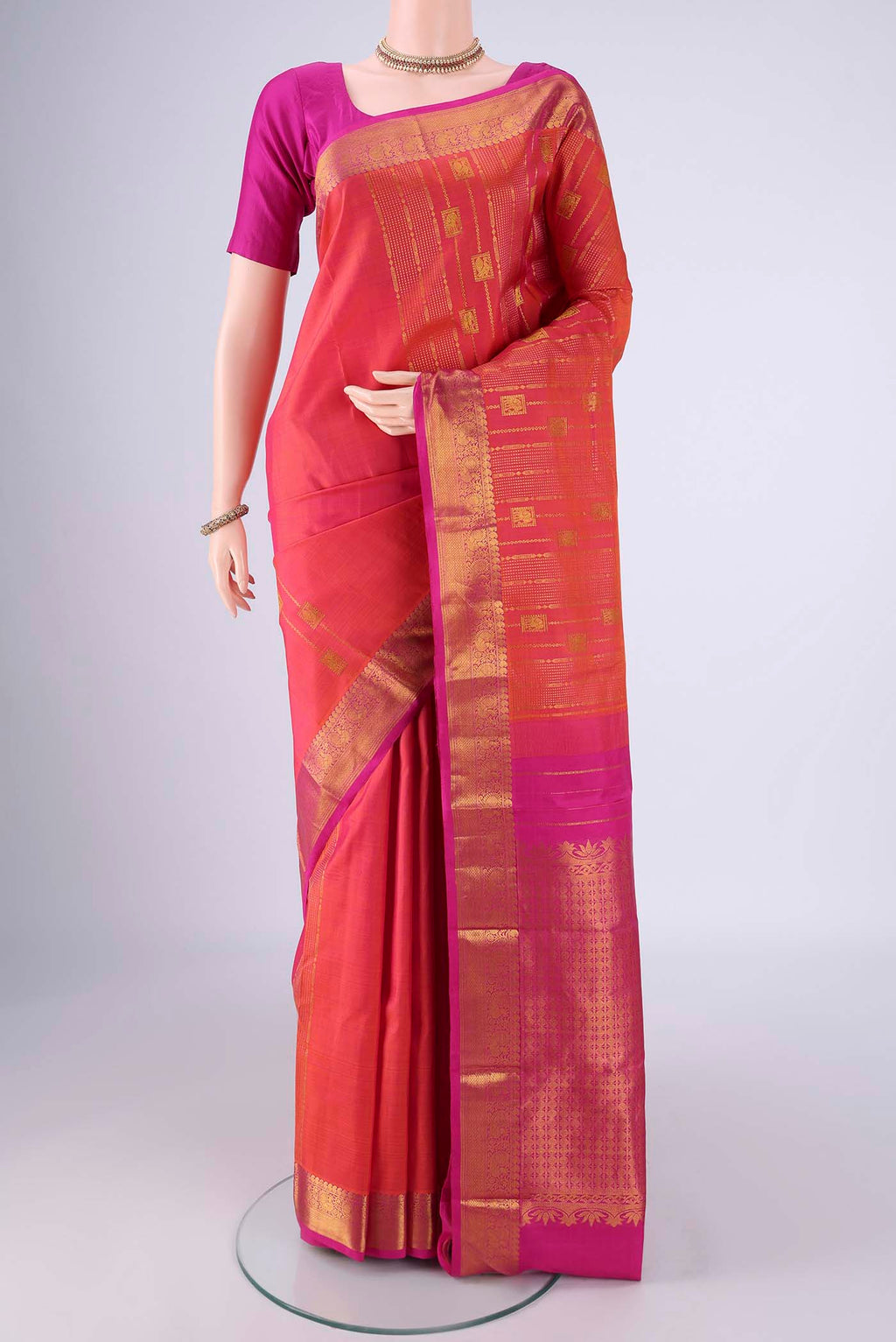 Brick Orange Dual Tone Kanjivaram Silk Saree with Zari Butta on the body and Zari Border.  displayed on a mannequin