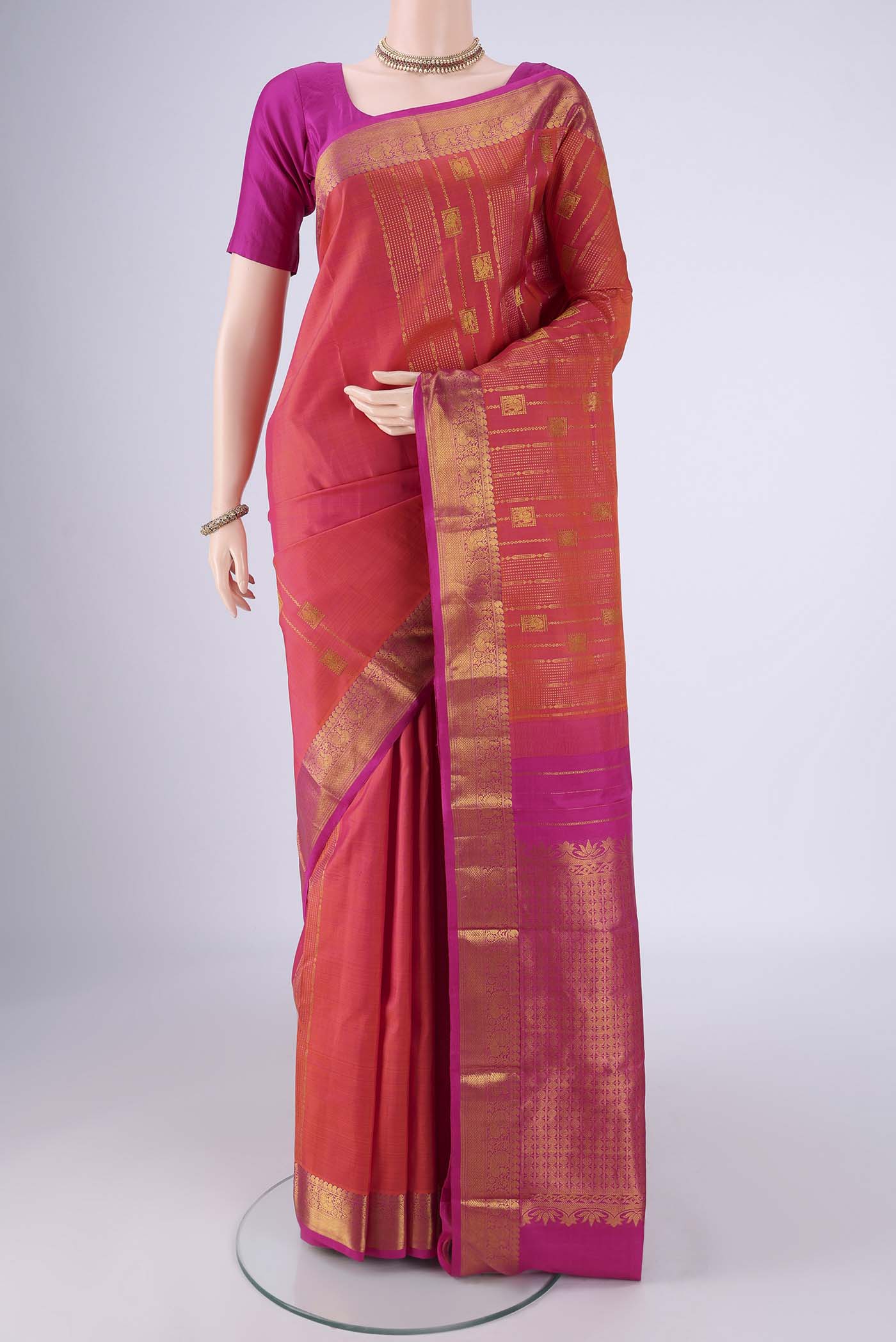 Brick Orange Dual Tone Kanjivaram Silk Saree with Zari Butta on the body and Zari Border.  displayed on a mannequin