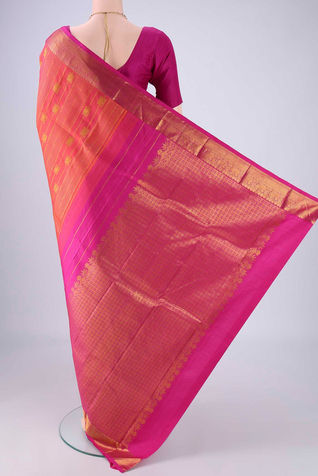 Flat view of Brick Orange Dual Tone Kanjivaram Silk Saree with Zari Butta on the body and Zari Border. 