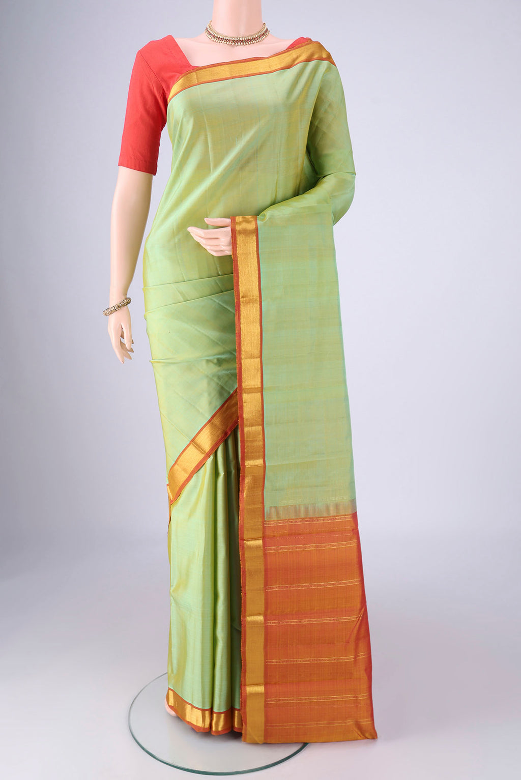 Light Green Kanjivaram Silk Saree with Plain Body and Zari Border.  displayed on a mannequin