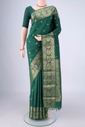 Bottle Green Kanjivaram Silk Saree with Zari Butta on the body and Zari Border.  displayed on a mannequin