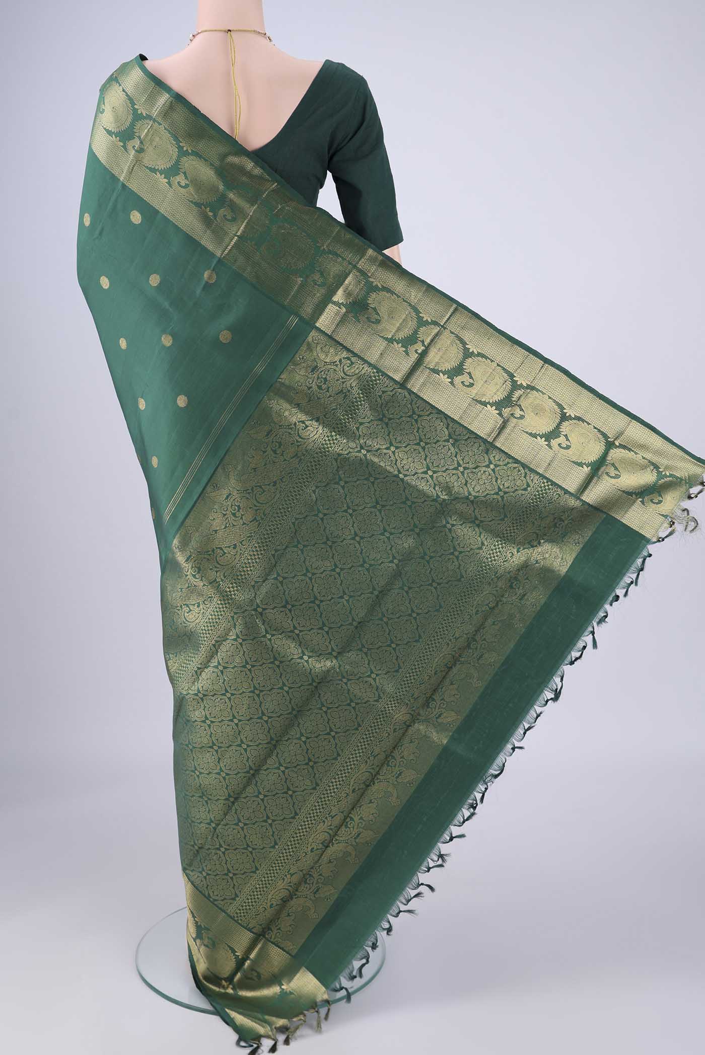 Flat view of Bottle Green Kanjivaram Silk Saree with Zari Butta on the body and Zari Border. 